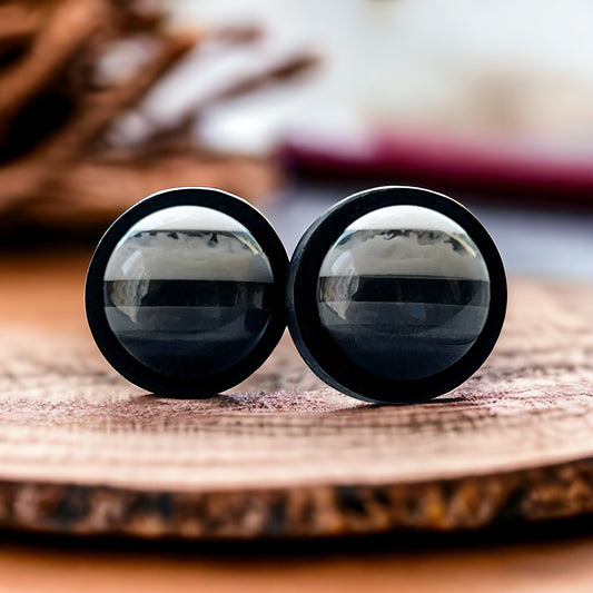 Handmade resin and wood stud earrings on neutral fabric backdrop