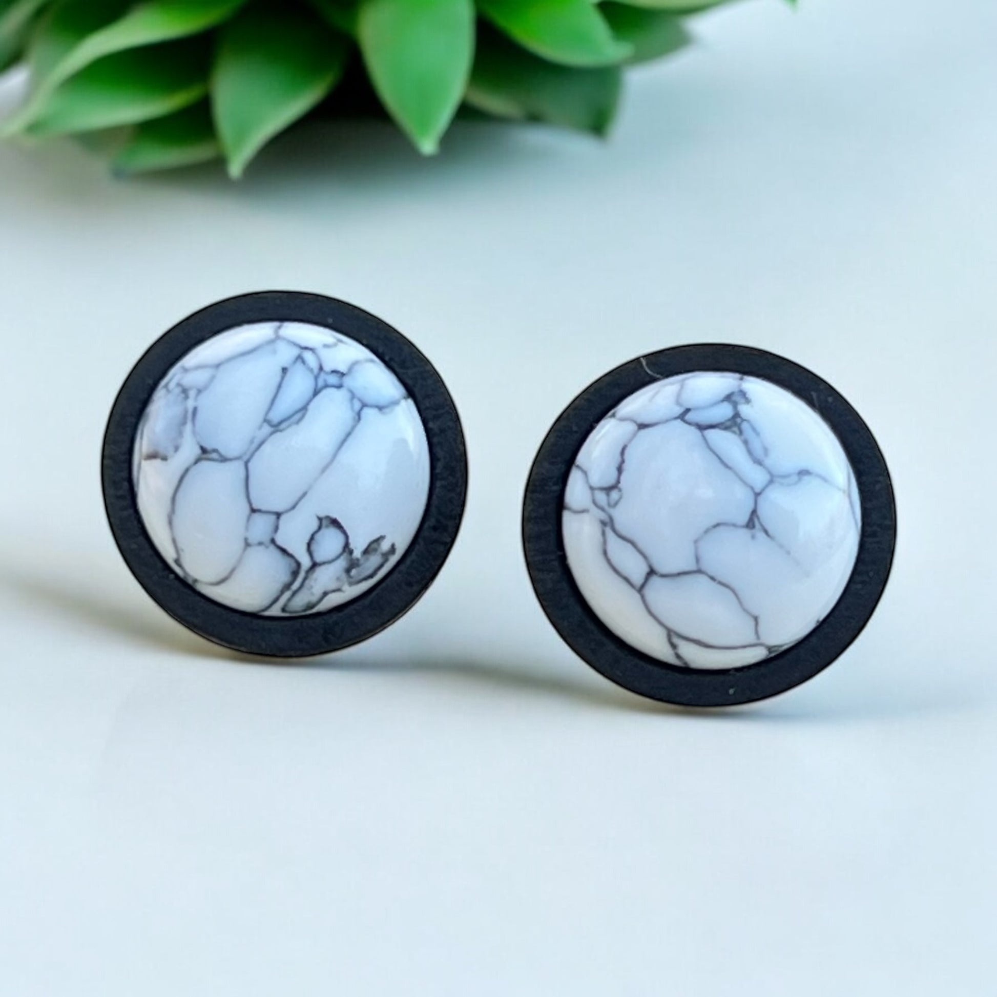Back view of handmade white and gray stud earrings