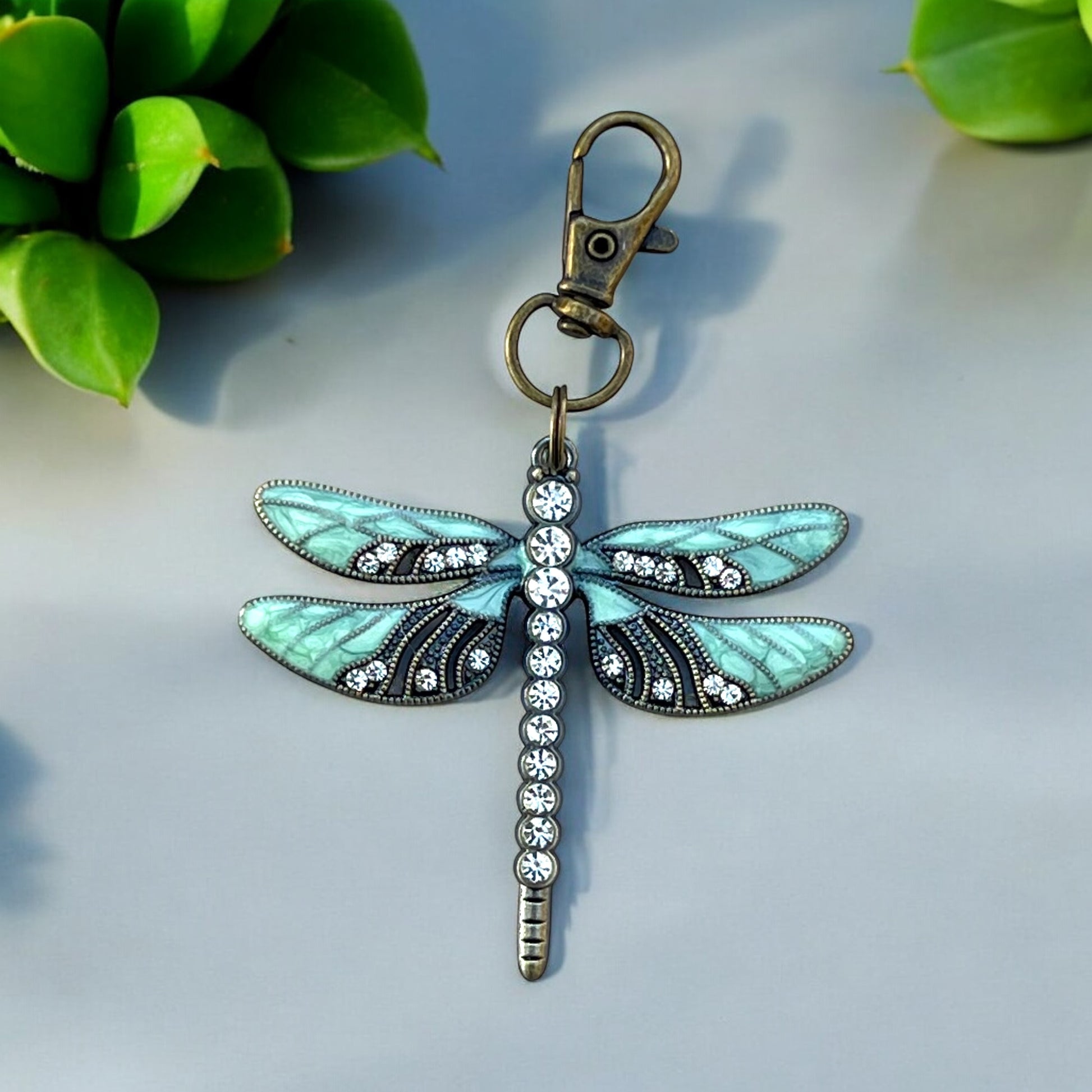 Mint and black rhinestone dragonfly charm on neutral background