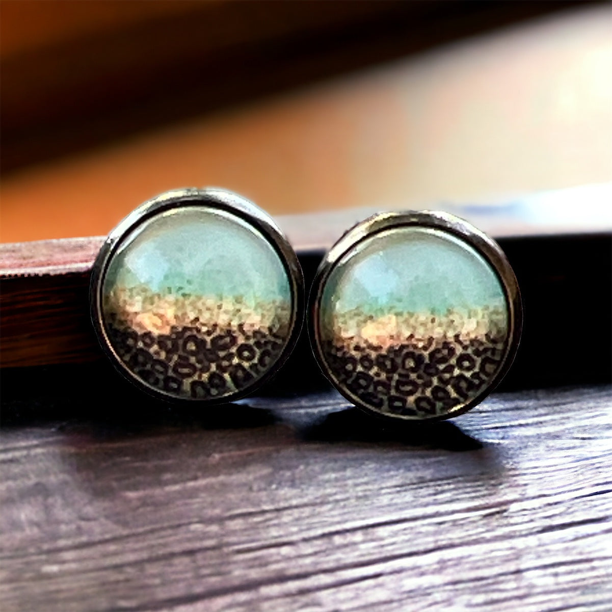 Mint Leopard Ombre Stud Earrings – on a wooden display with a warm background 