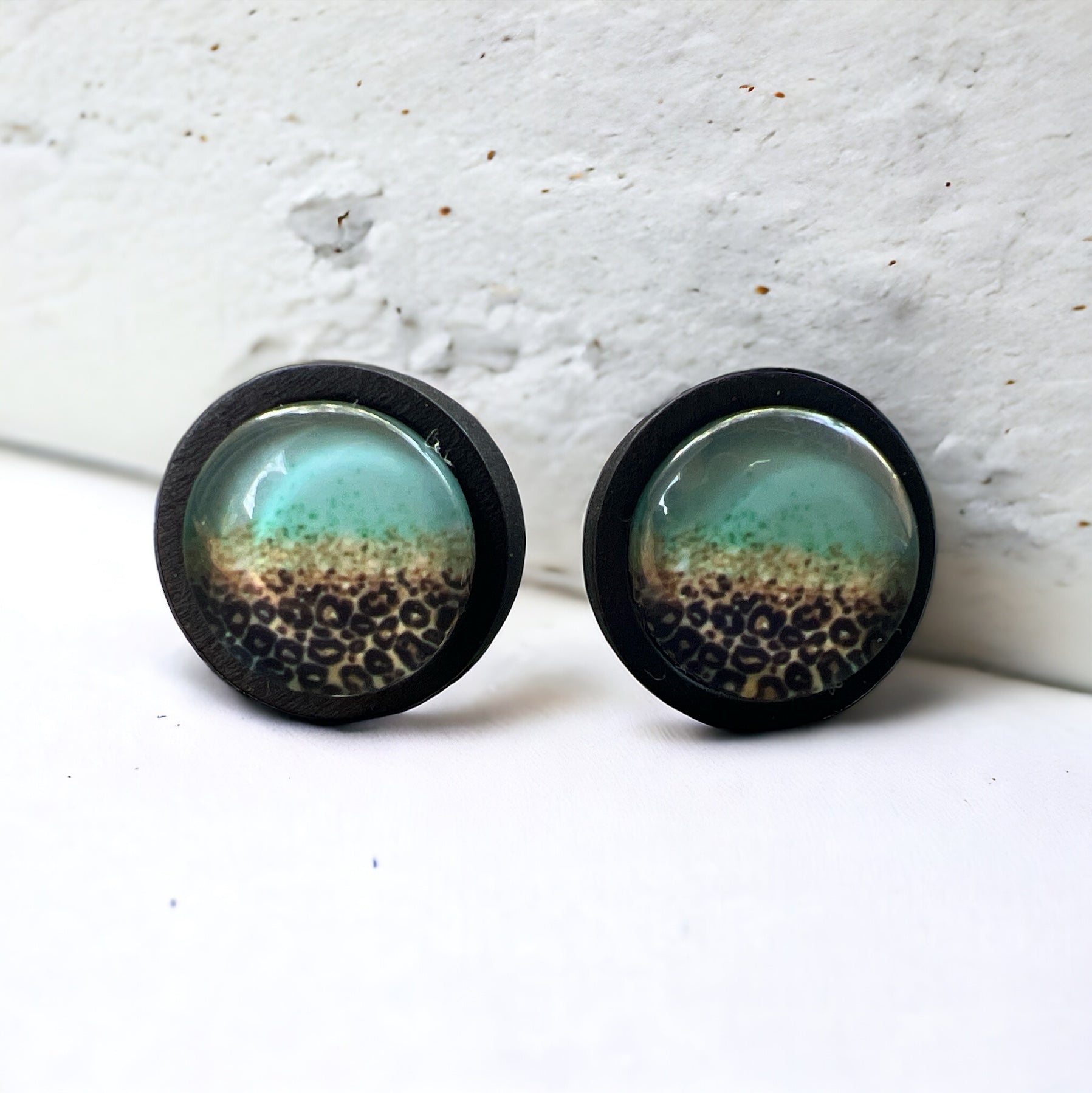 Turquoise Leopard Fade Resin Stud Earrings – Bold Handmade Boho Jewelry on white concrete.