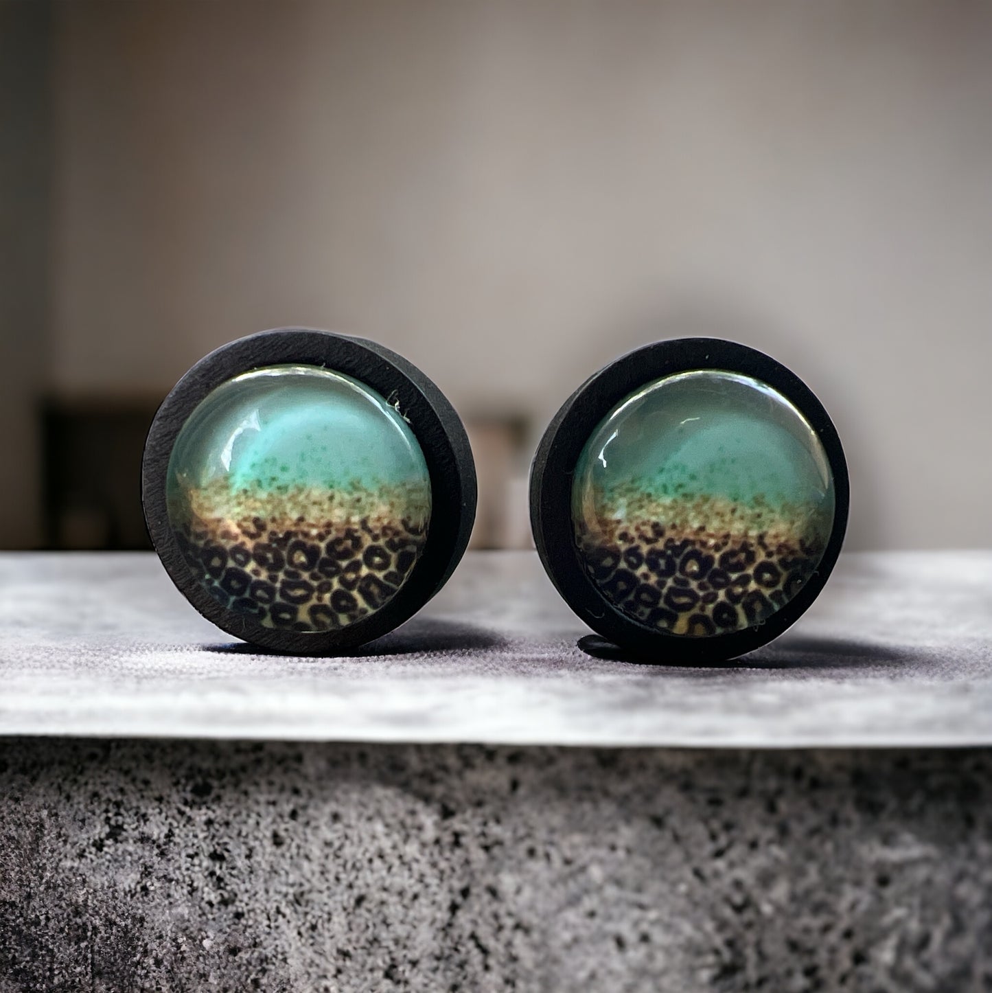 Mint Leopard Fade Resin Stud Earrings – Bold Handmade Boho Jewelry on a rock slat