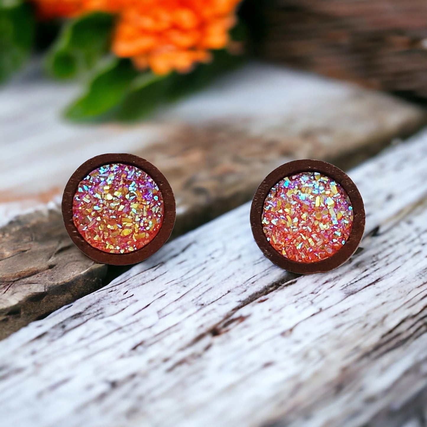 Round orange druzy wood stud earrings displayed on a wood surface