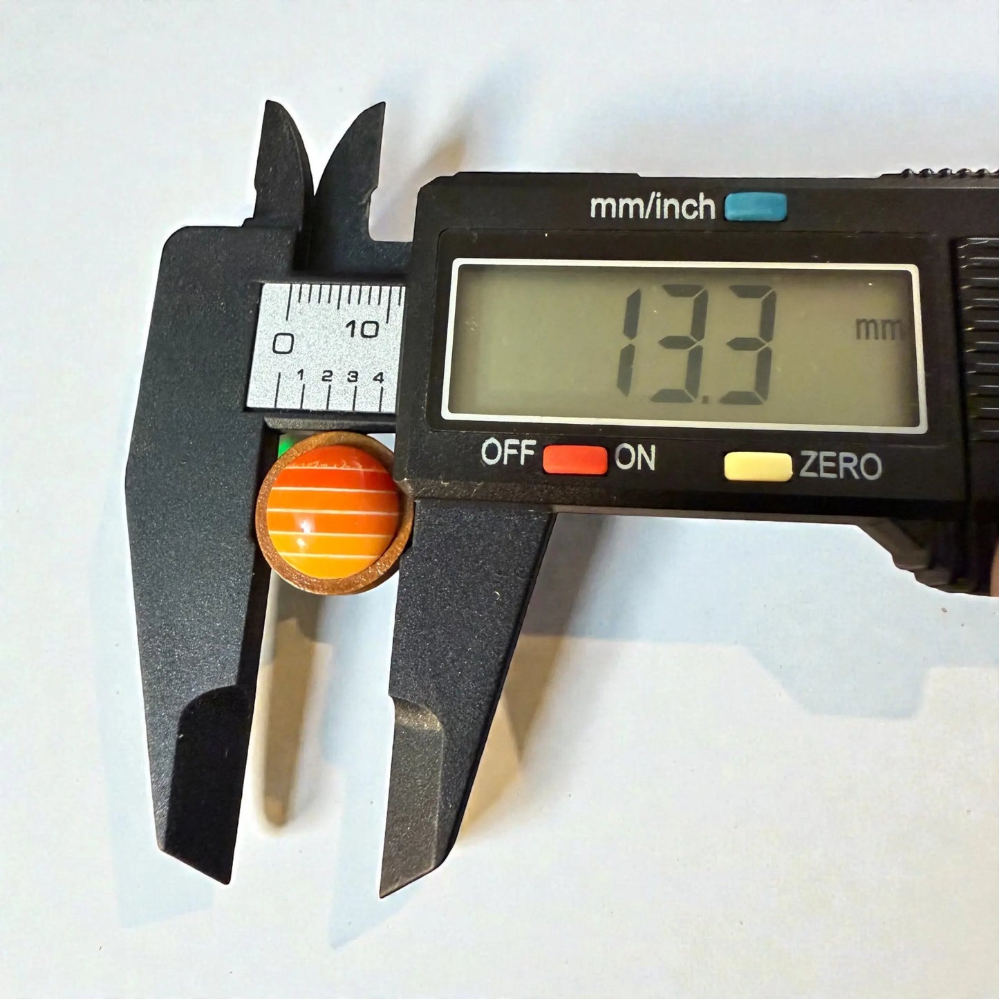 Round orange gradient striped wood stud earrings with digital measurements in millimeters 