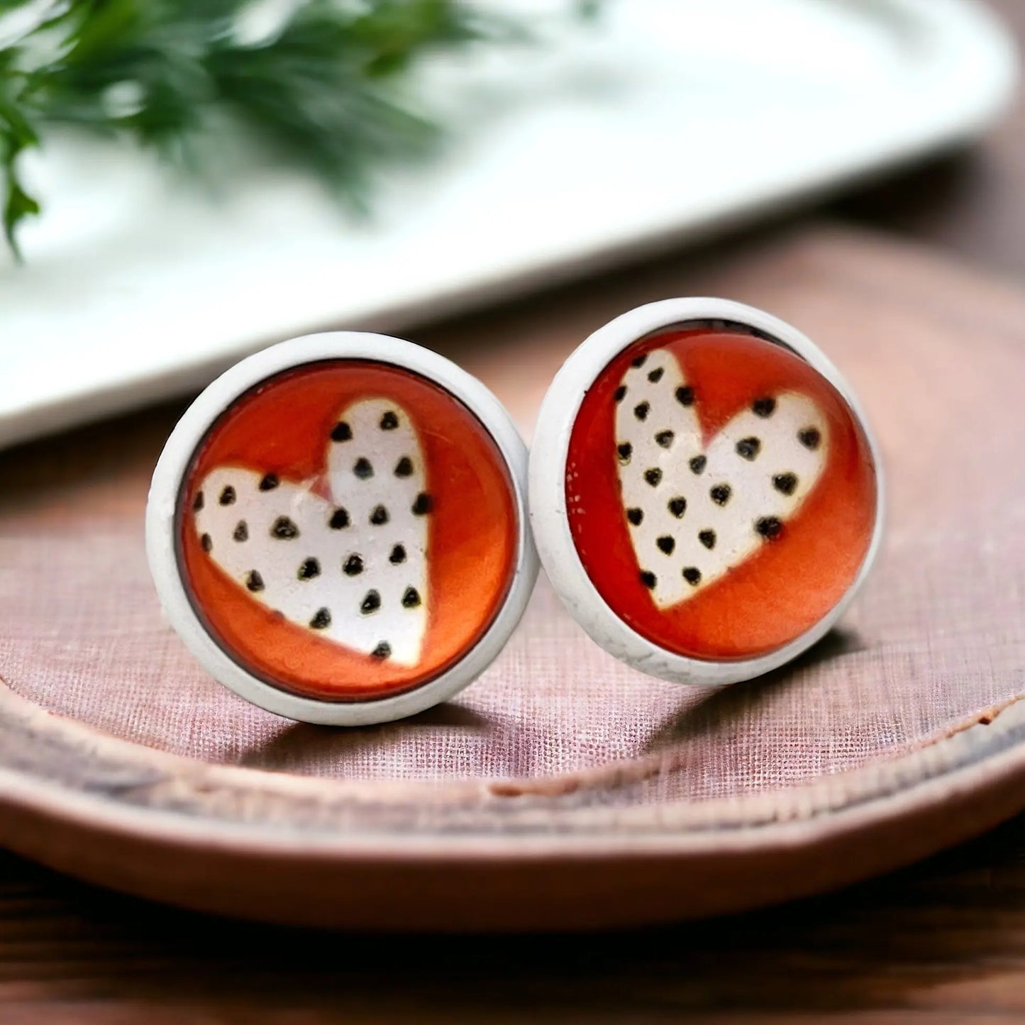 Pair of earrings with heart design on a wooden surface