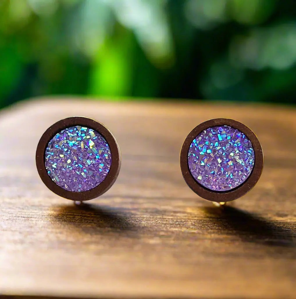 Round purple glitter druzy wood stud earrings displayed on a wood surface
