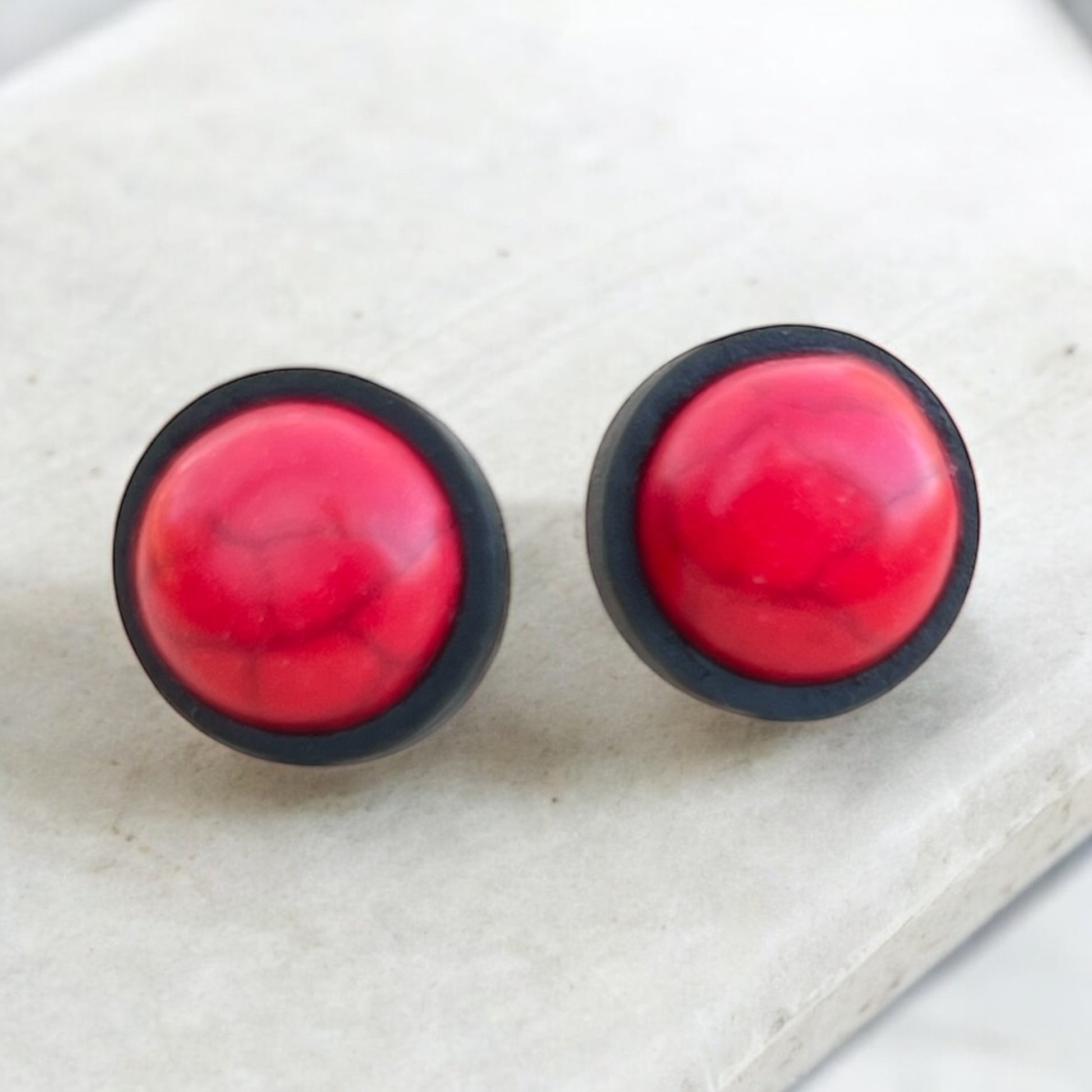 Red marble pattern earrings on white display background
