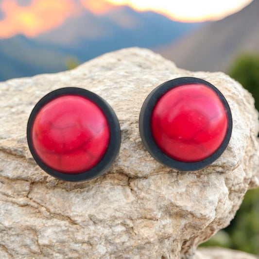 Flat lay of red stone stud earrings with marbled synthetic cabochons in wood bezels