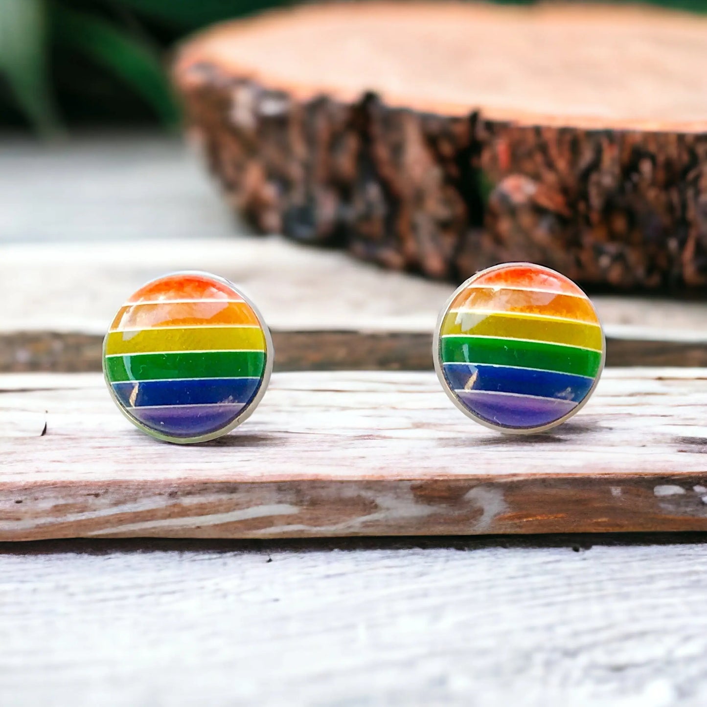 Rainbow striped earrings on a wooden surface