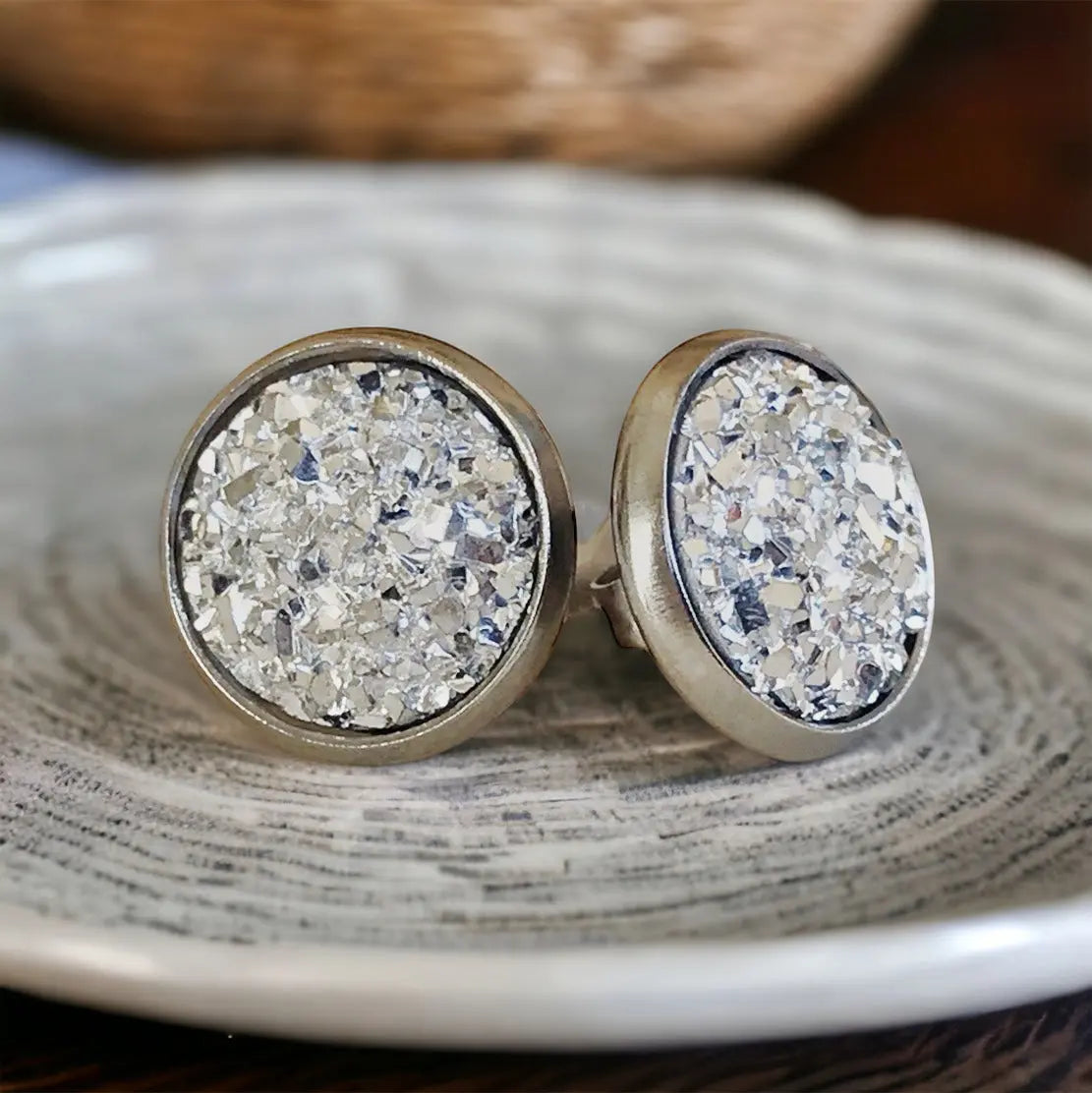 Round silver earrings with a textured surface on a textured surface