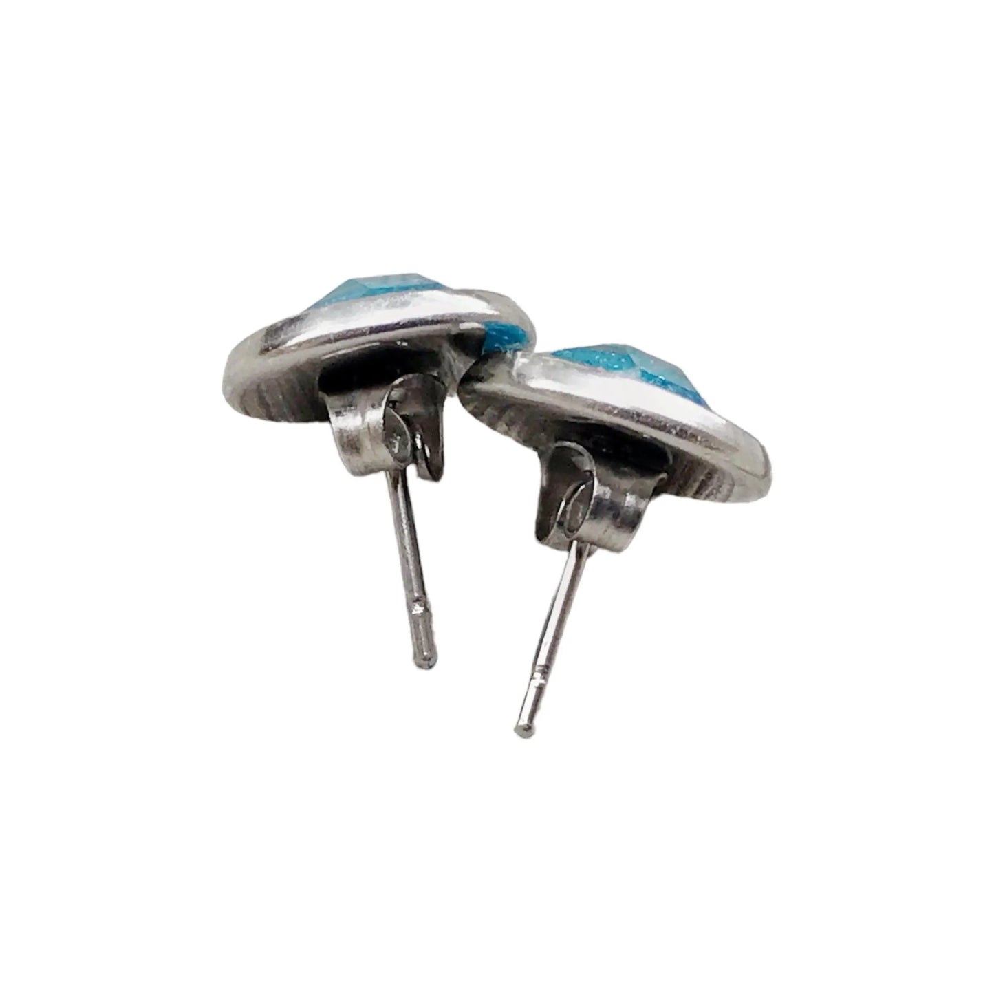 Back of round sky blue glitter stud earrings in a silver-tone setting displayed on a white background 