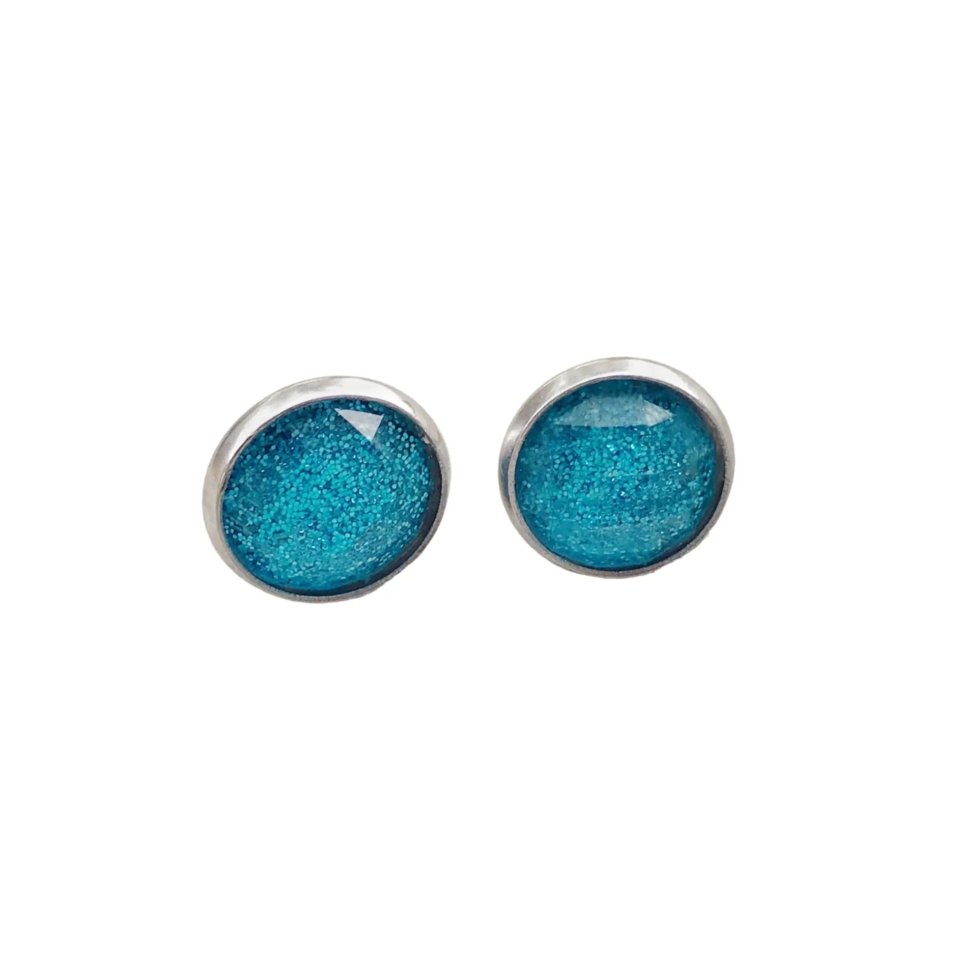 Round sky blue glitter stud earrings in a silver-tone setting displayed on a white background 