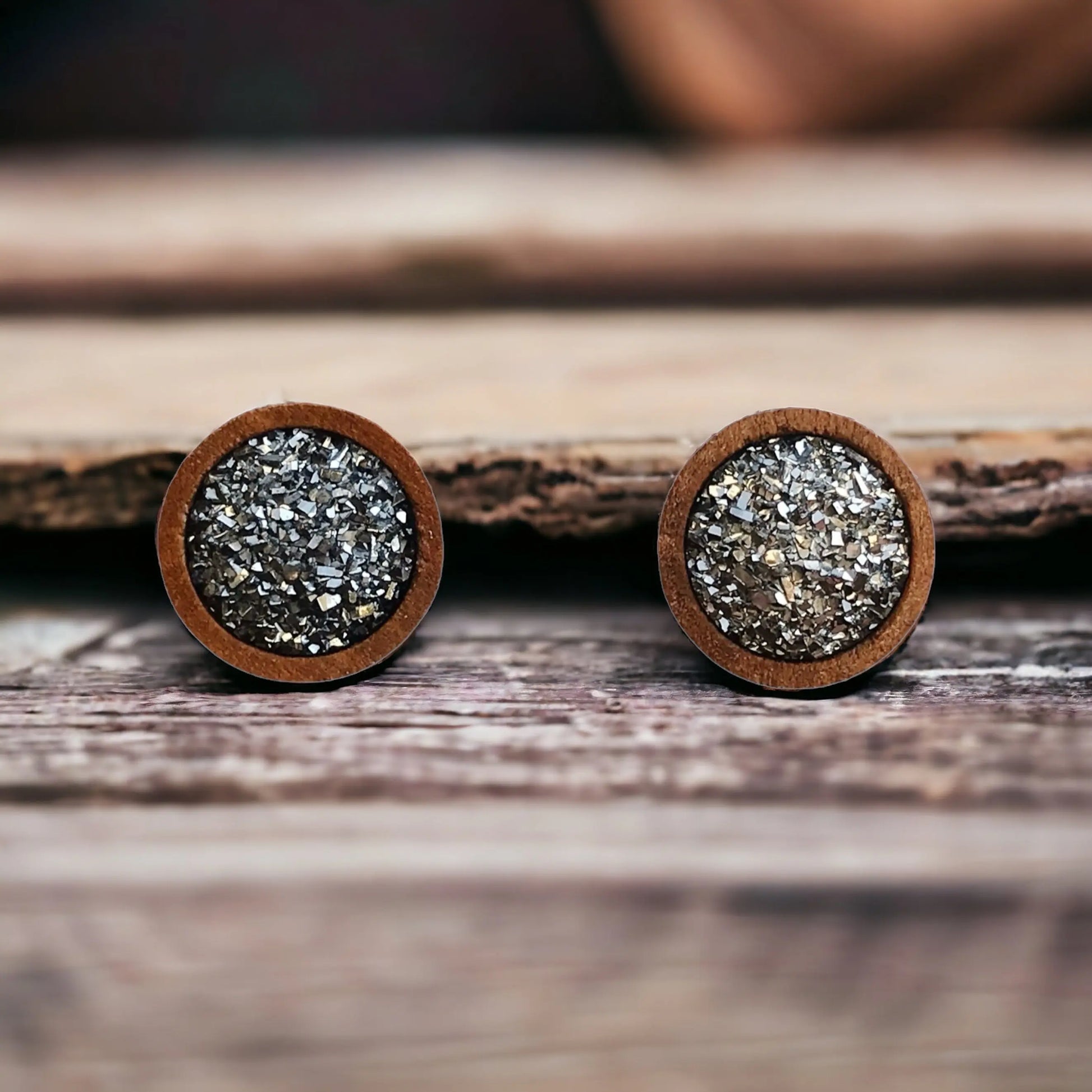 Round gray druzy wood stud earrings displayed on a rustic wood surface