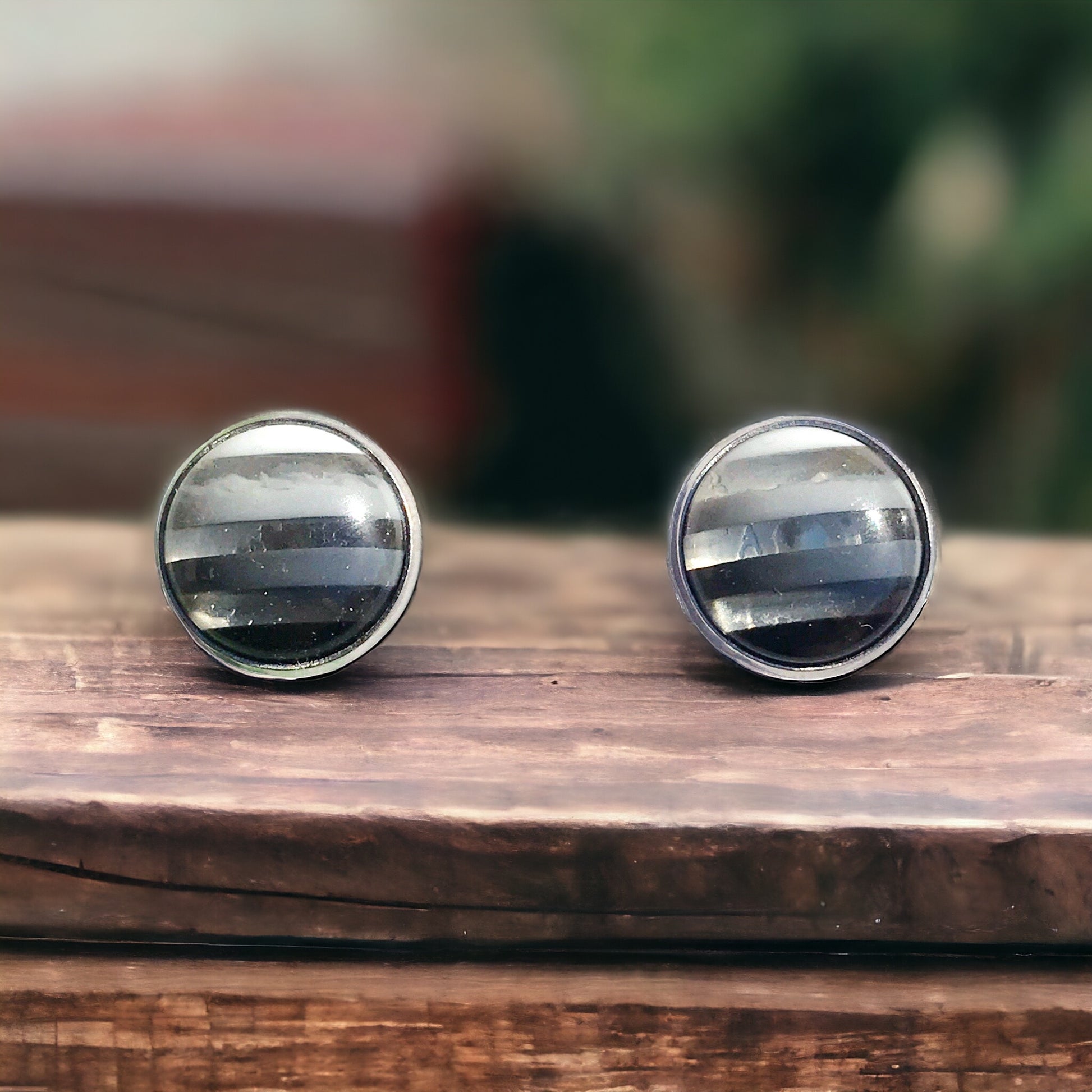 Close-up of 12mm striped resin earrings in silver setting