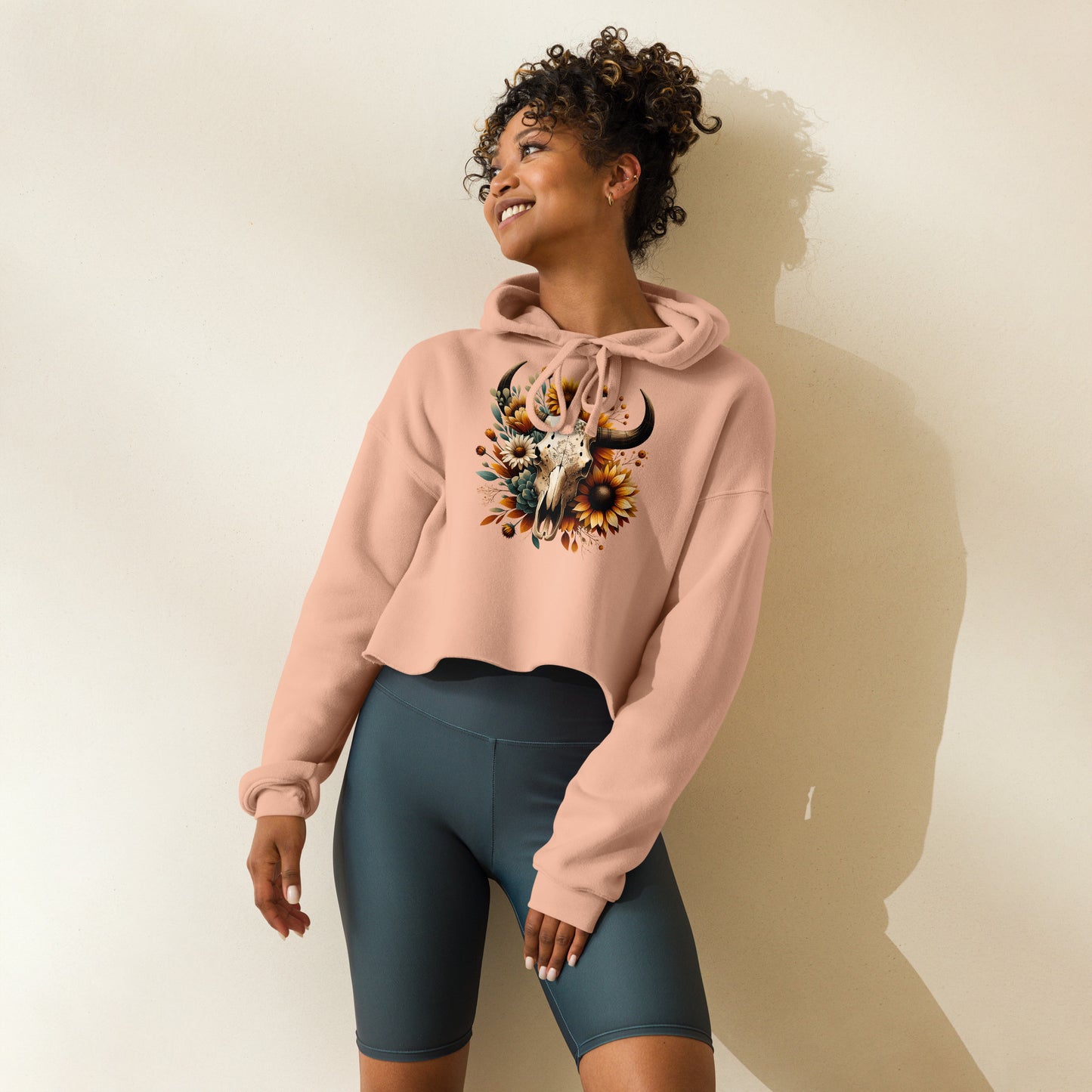 Side view of peach crop hoodie with rustic skull and fall floral design
