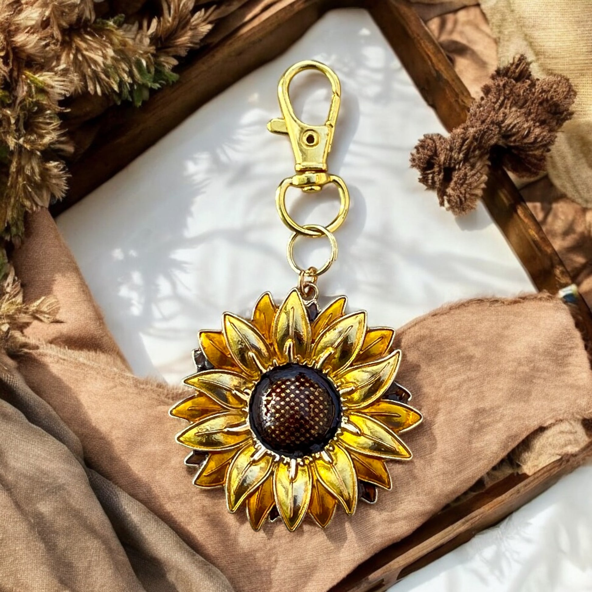 Sunflower handbag charm displayed with rustic textures and linens