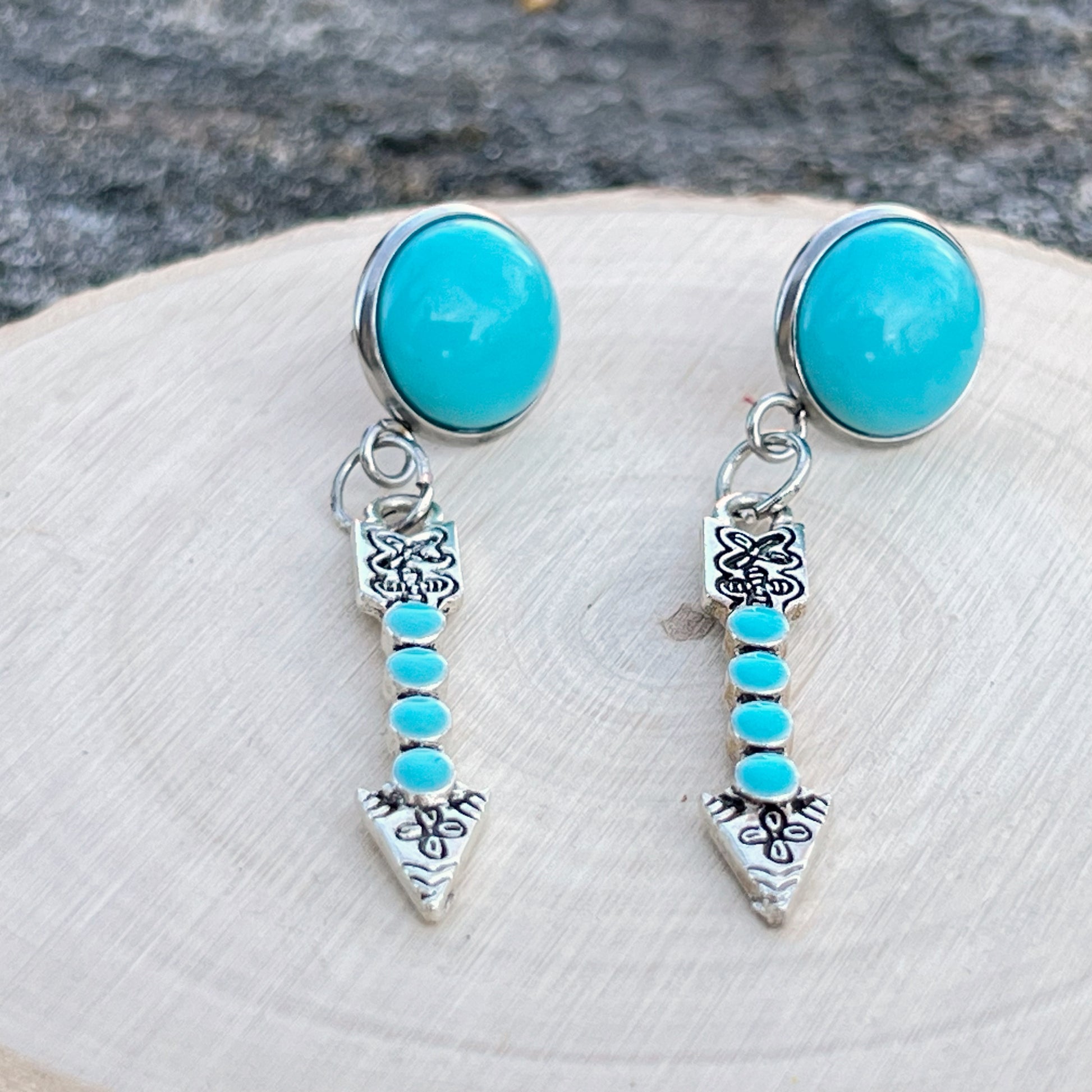 Turquoise Arrow Earrings – Handmade Boho Western Dangles- on wood slice display 