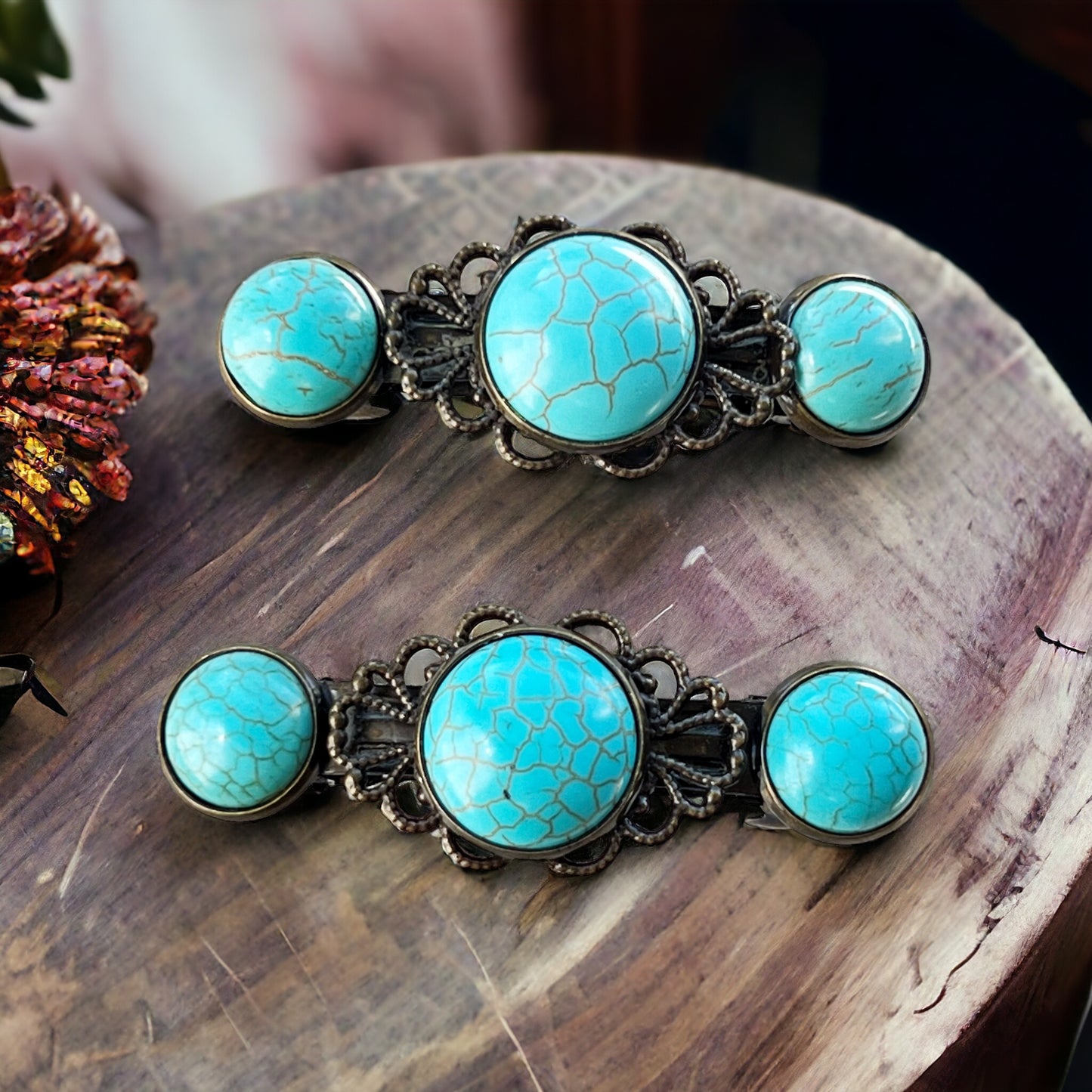 Set of two western bridal hair barrettes with faux turquoise stones and antique bronze-tone detail on a wood display