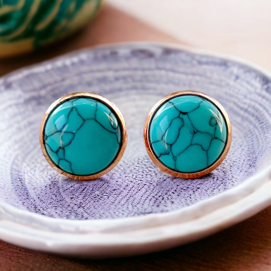 Round turquoise rose gold stud earrings displayed on a light surface