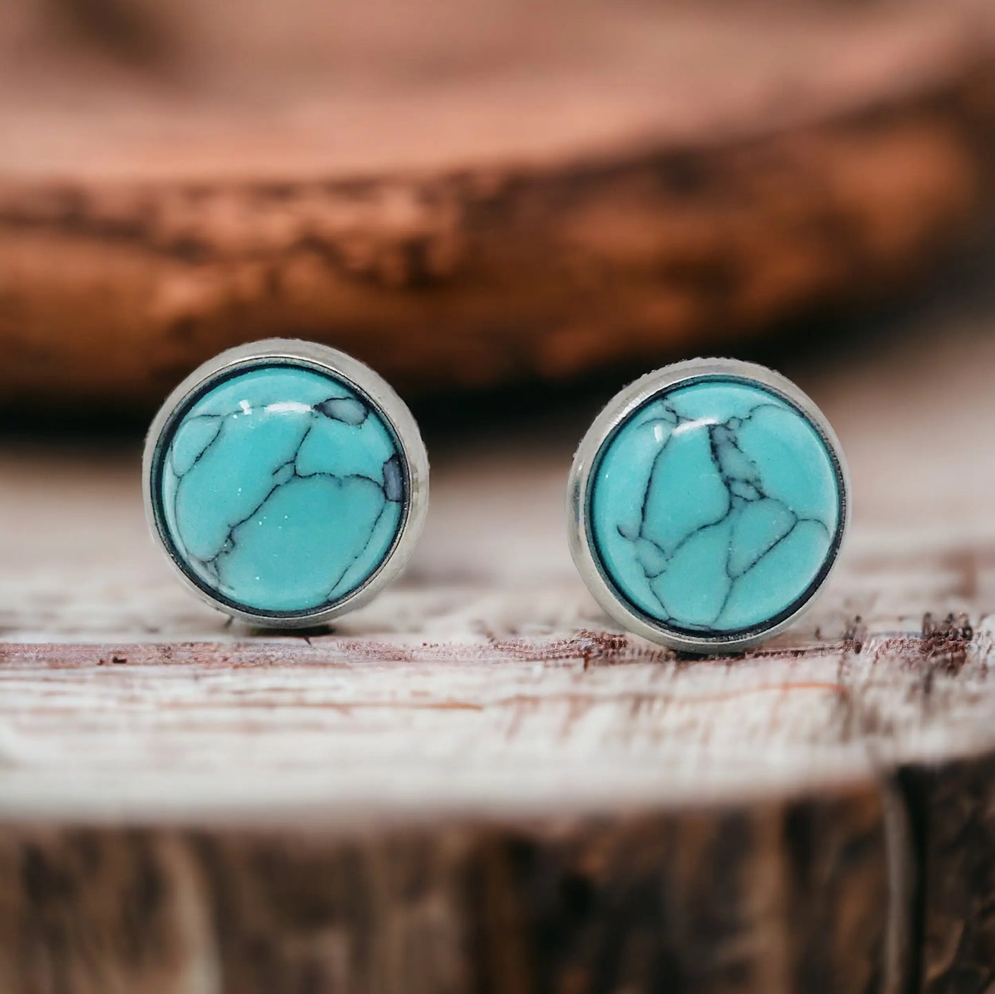 Close-Up of round turquoise stud earrings in a silver-tone setting displayed on a rustic wood surface
