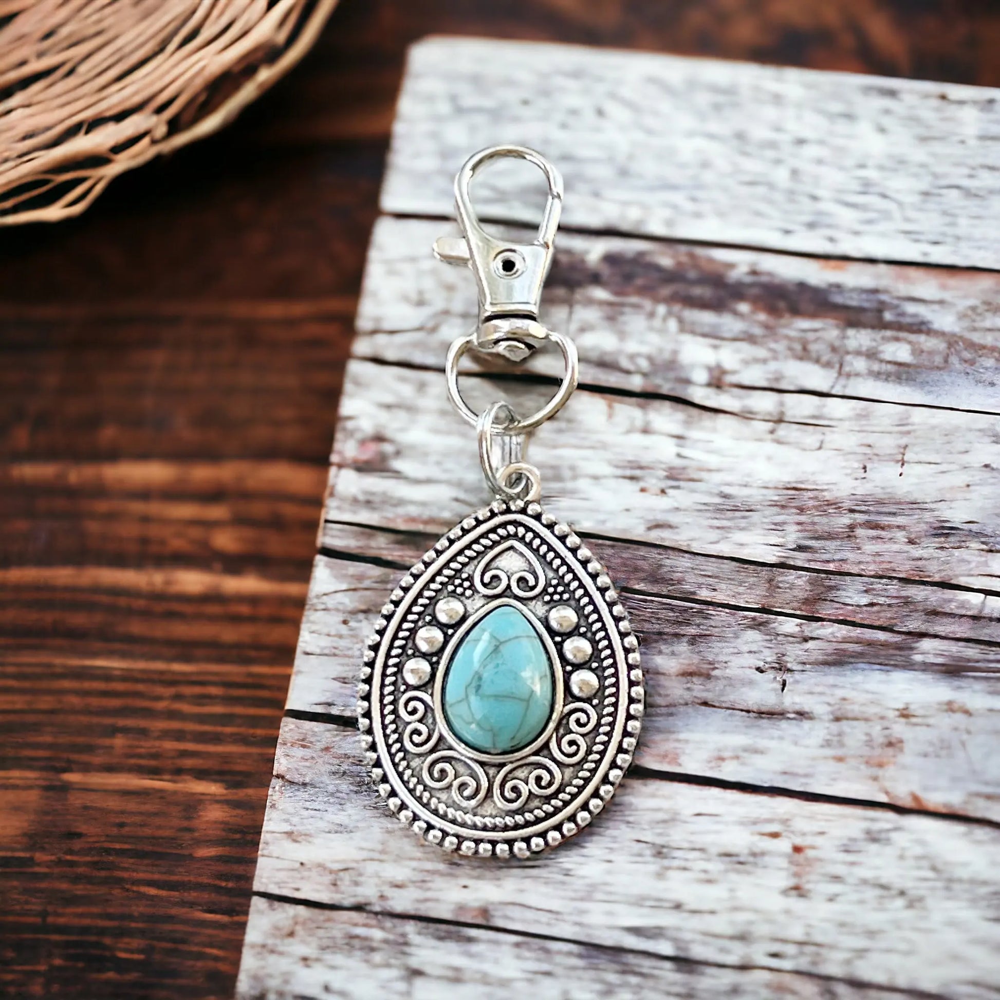 Western handbag charm with ornate medallion detail and faux turquoise accent on a styled wood display