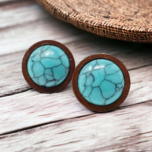 Round turquoise wood stud earrings displayed on a rustic wood surface