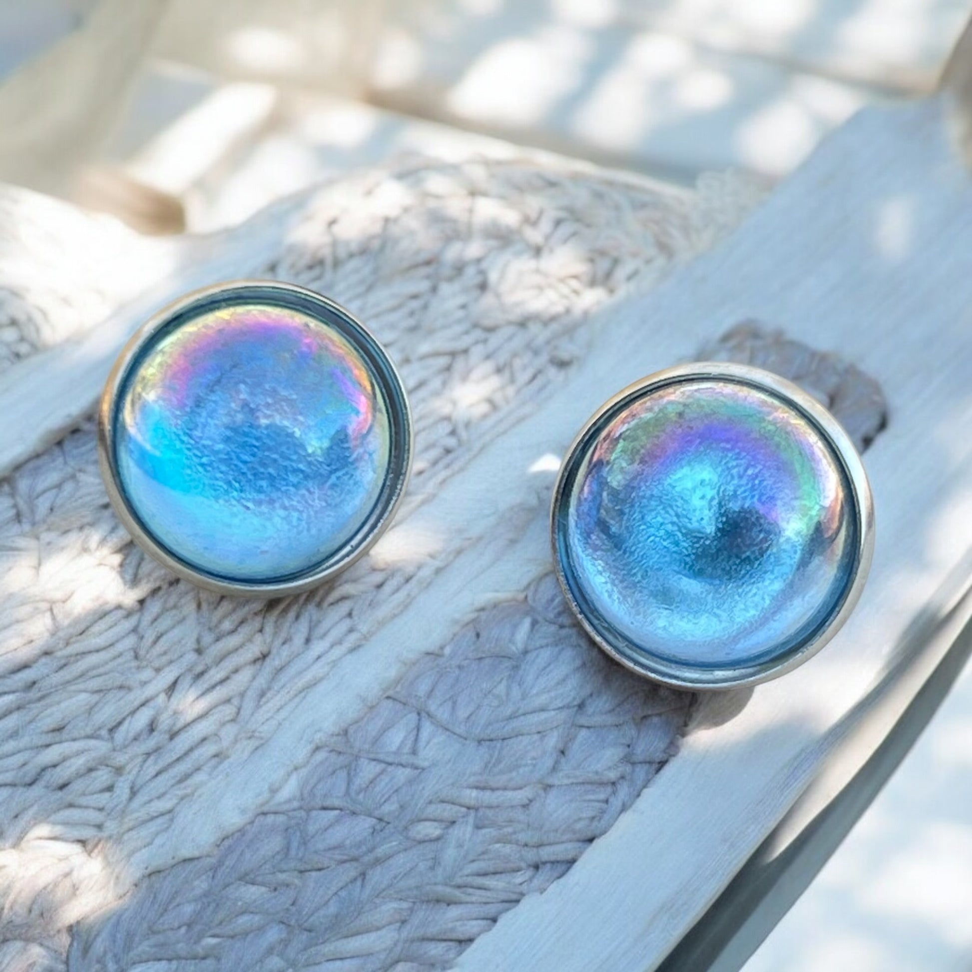 Blue shimmer earrings styled with neutral props