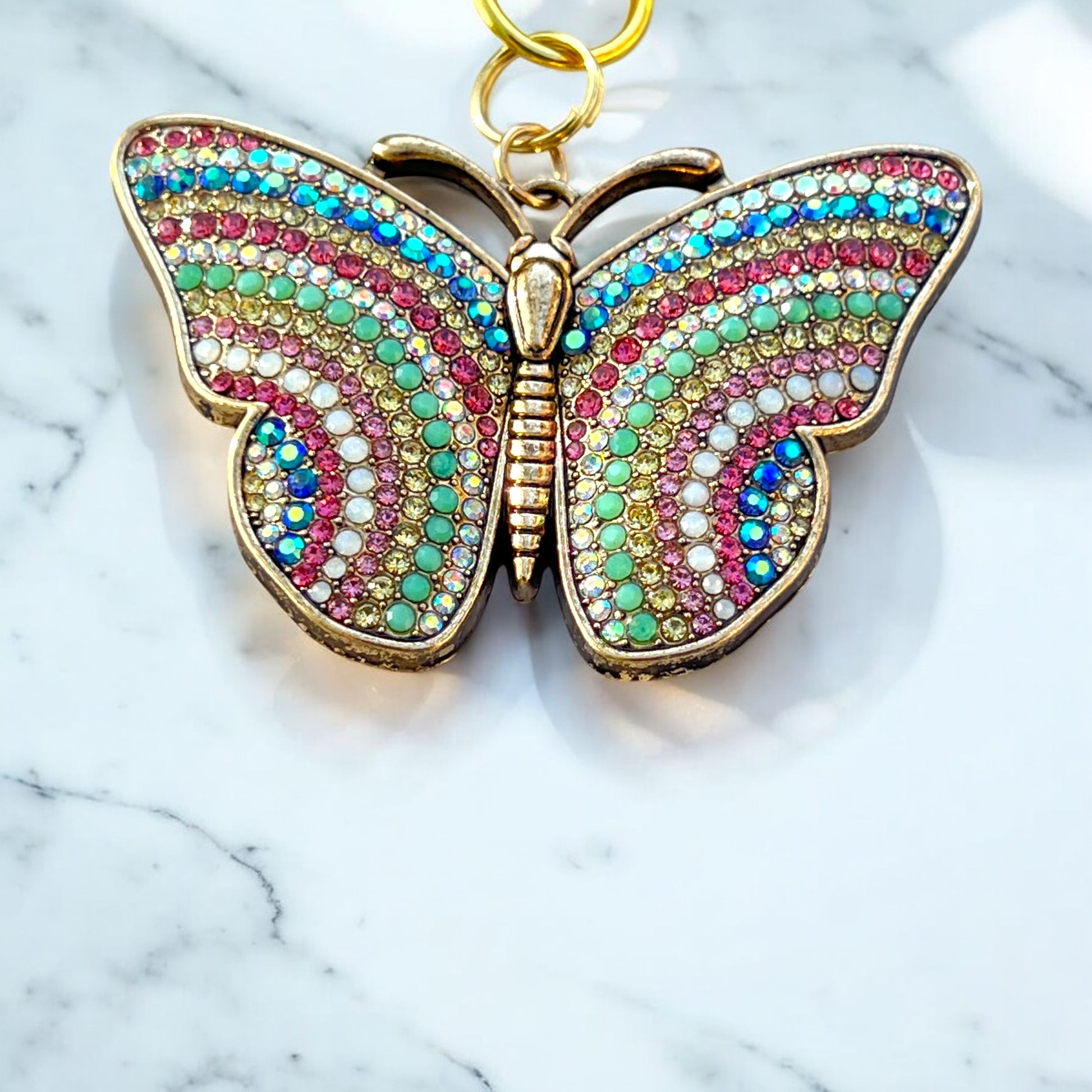 Whimsical butterfly keychain styled on tan leather purse