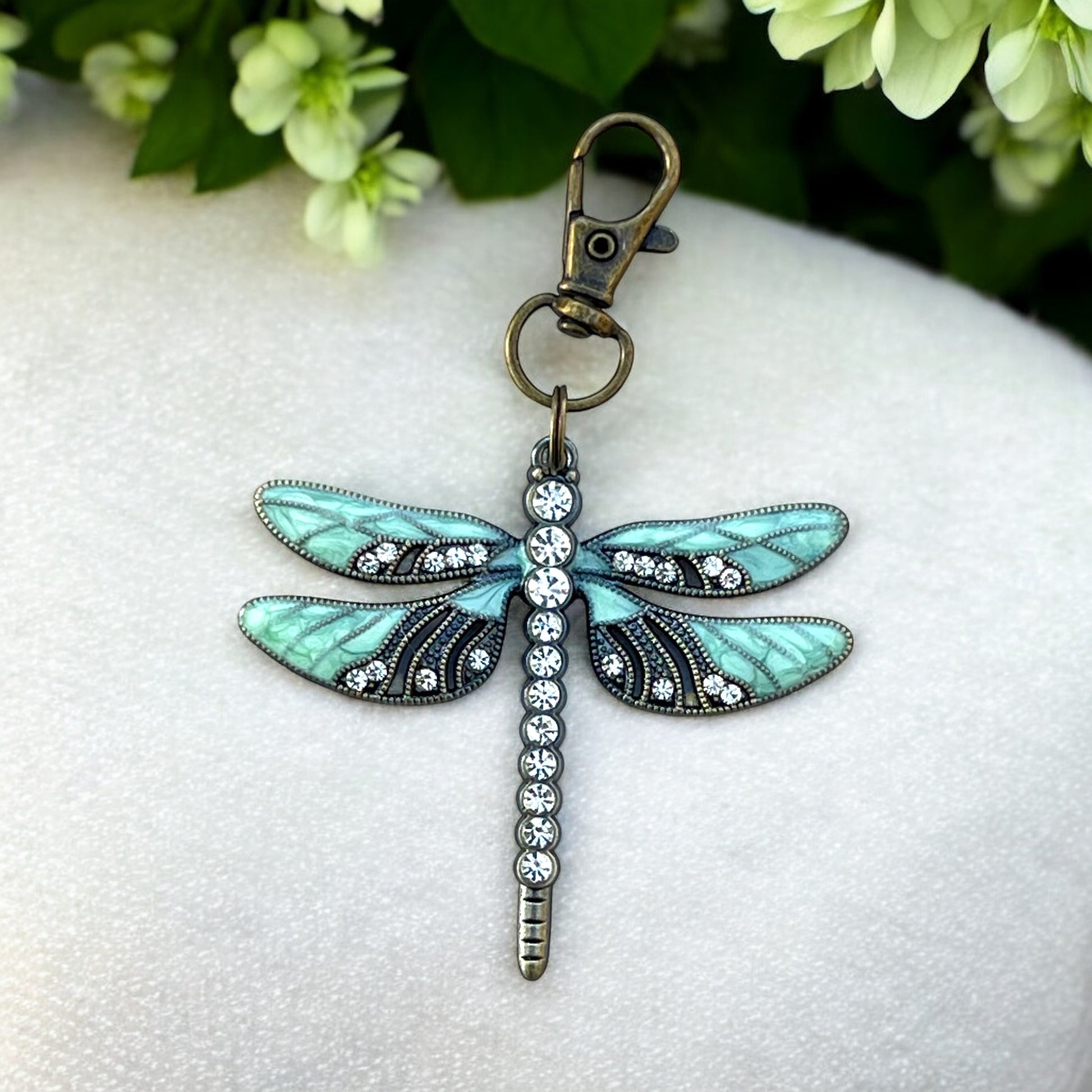 Whimsical dragonfly bag charm in mint, black, and clear rhinestones