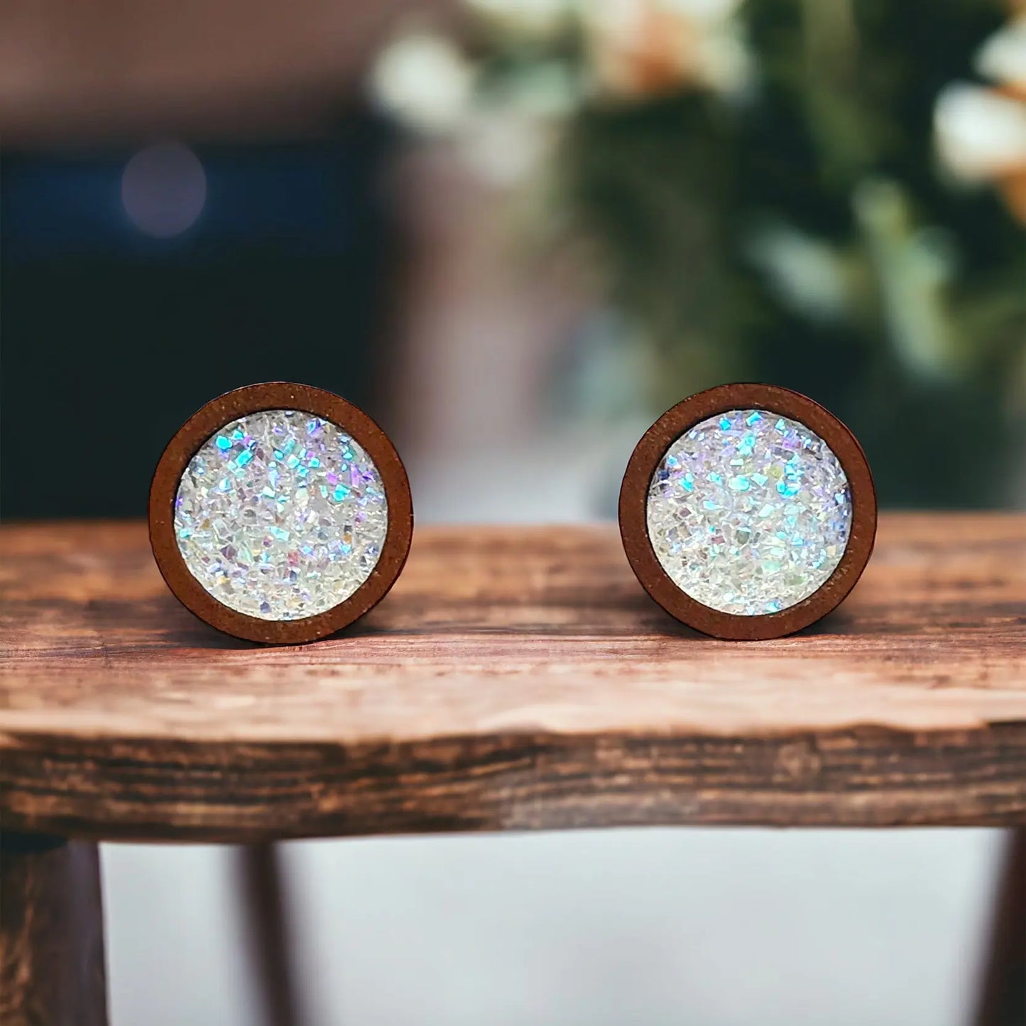 Round white glitter druzy wood stud earrings displayed on a rustic wood boho surface