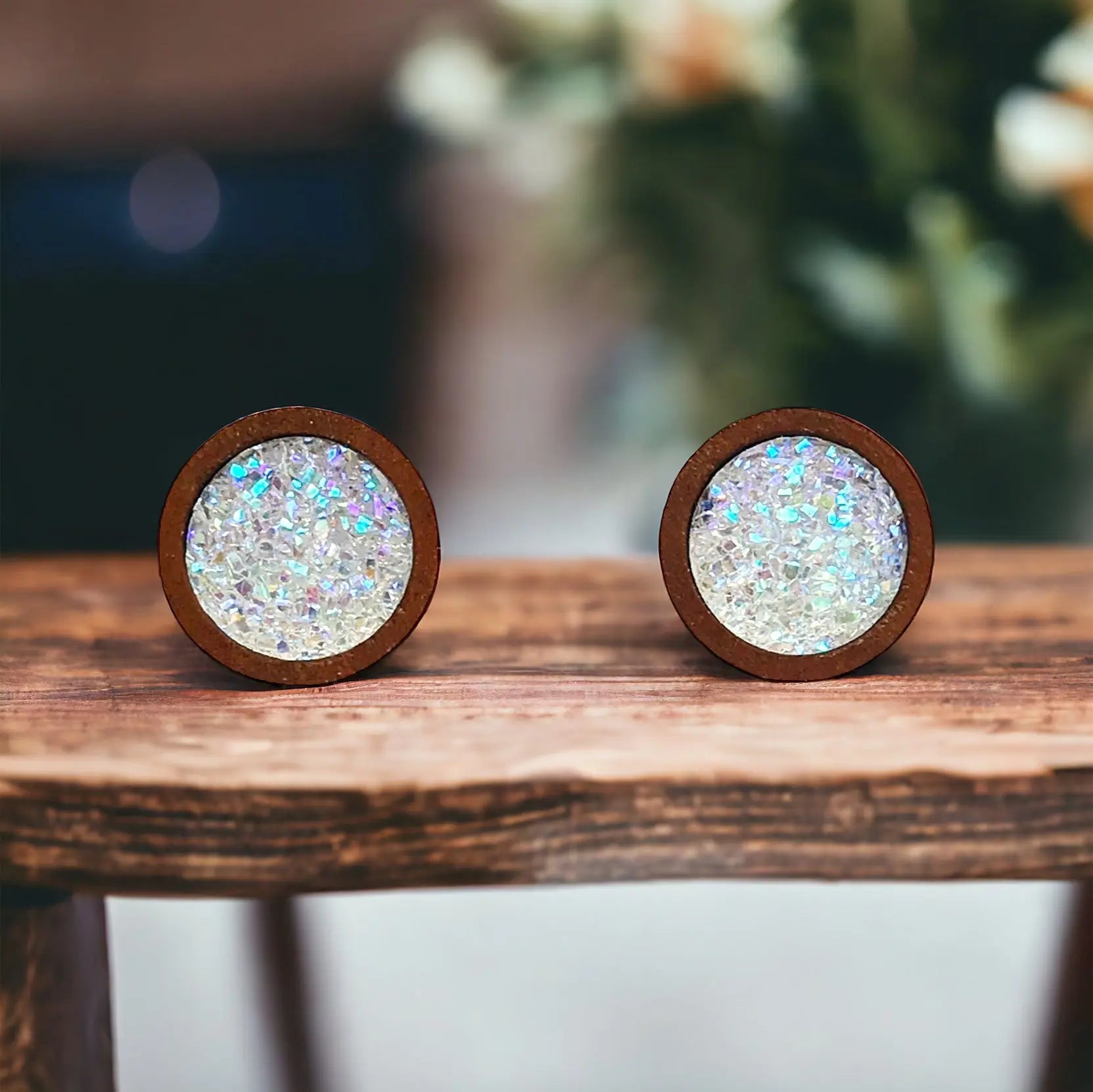 Round white glitter druzy wood stud earrings displayed on a rustic wood boho surface