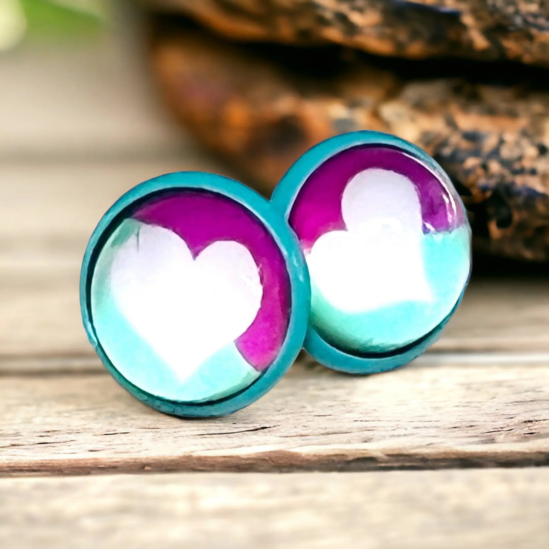 Heart-shaped earrings with teal and purple gradient on a wooden surface