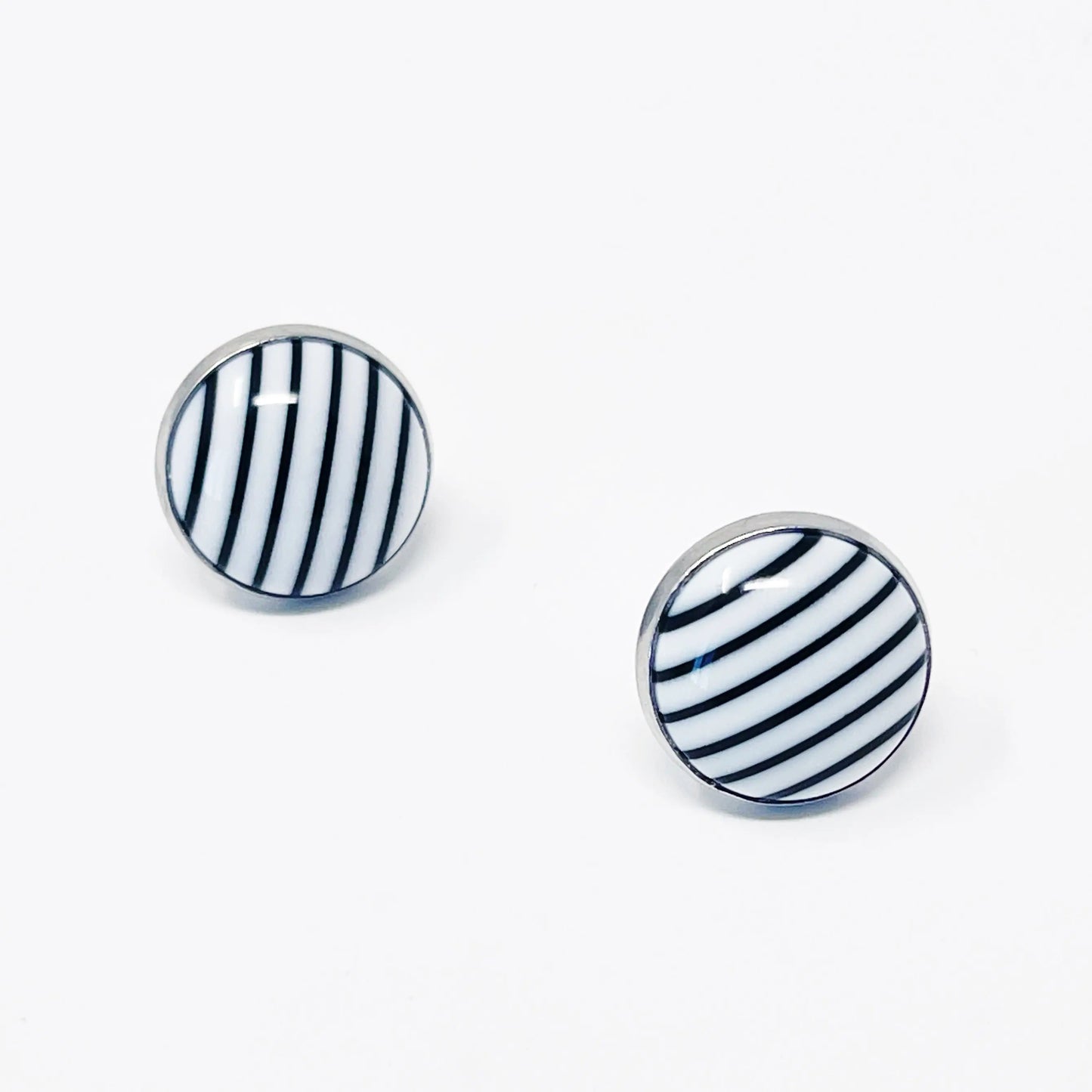 Pair of round earrings with black and white striped design on a white background