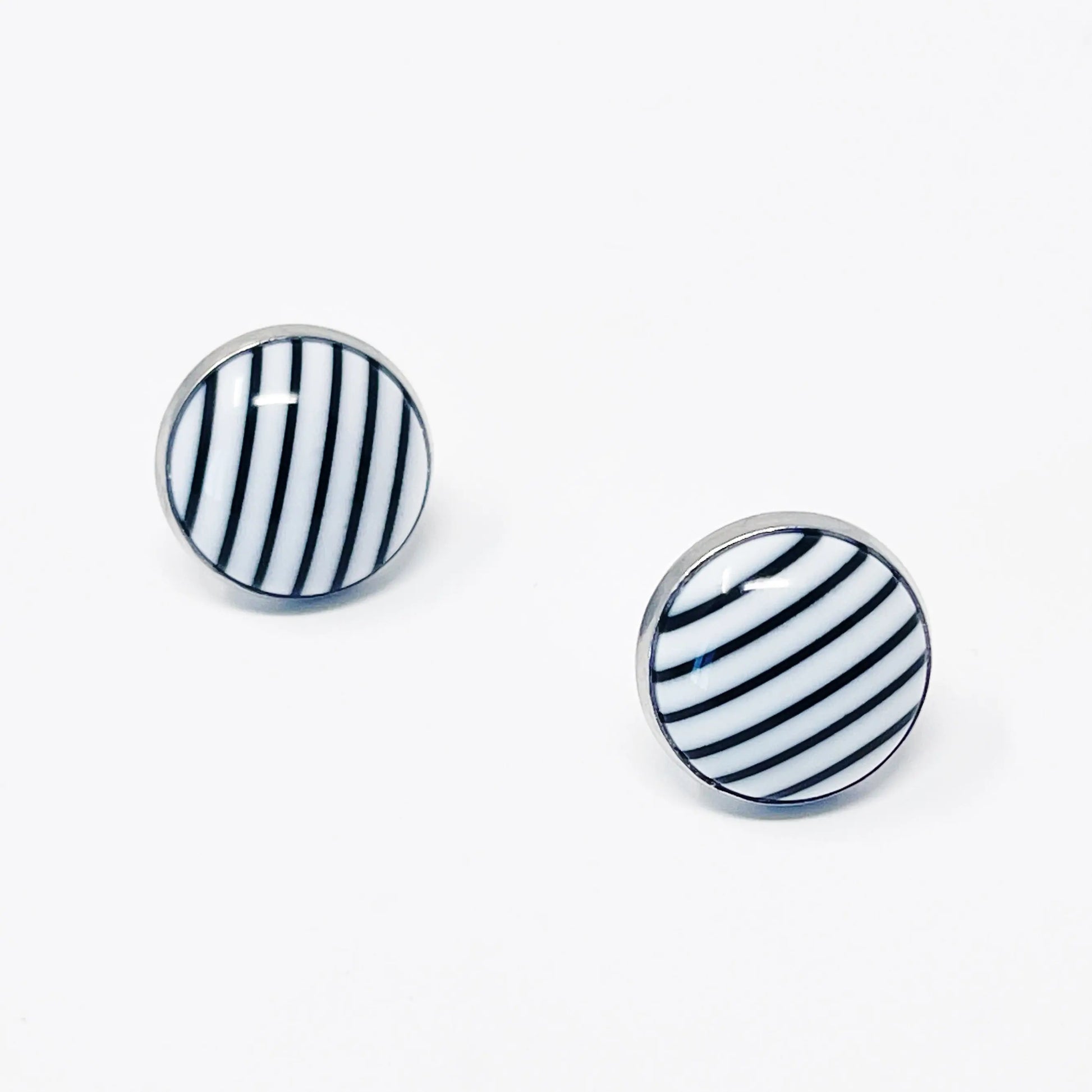 Pair of round earrings with black and white striped design on a white background