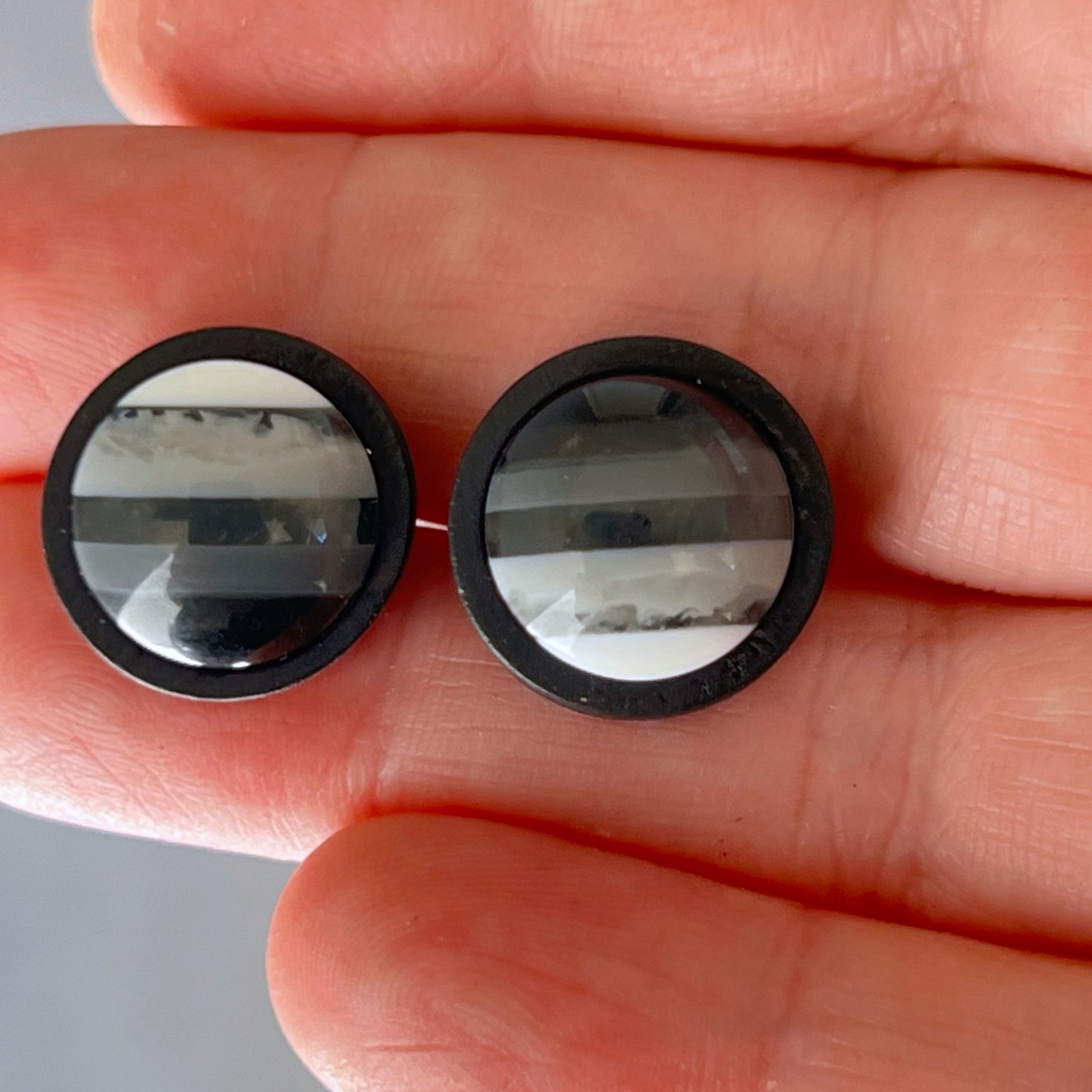 Black and white earrings shown from side angle with shadow