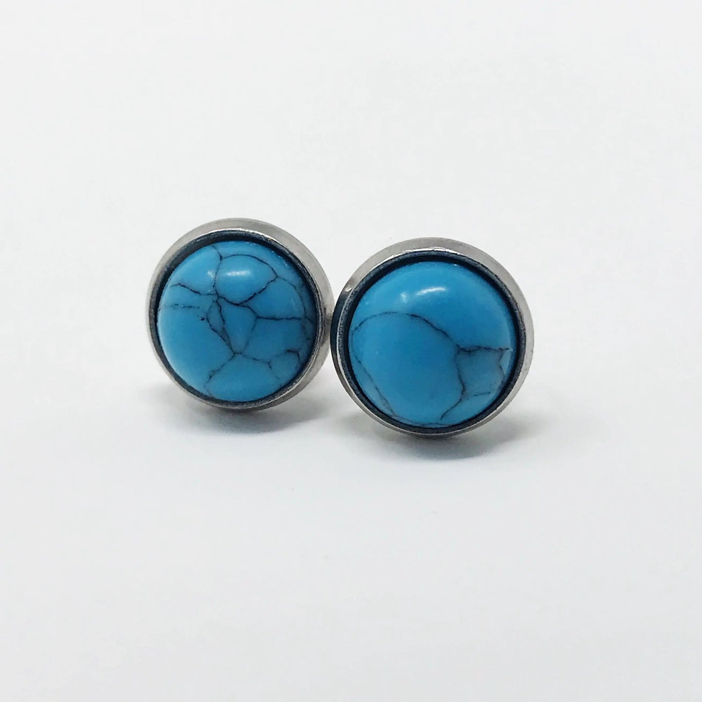 Round blue stone stud earrings in a silver-tone setting on a white background