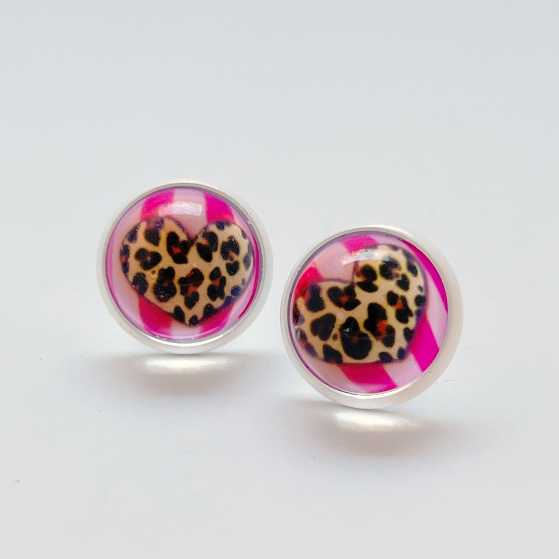 Bold everyday earrings with cheetah heart design displayed on white surface