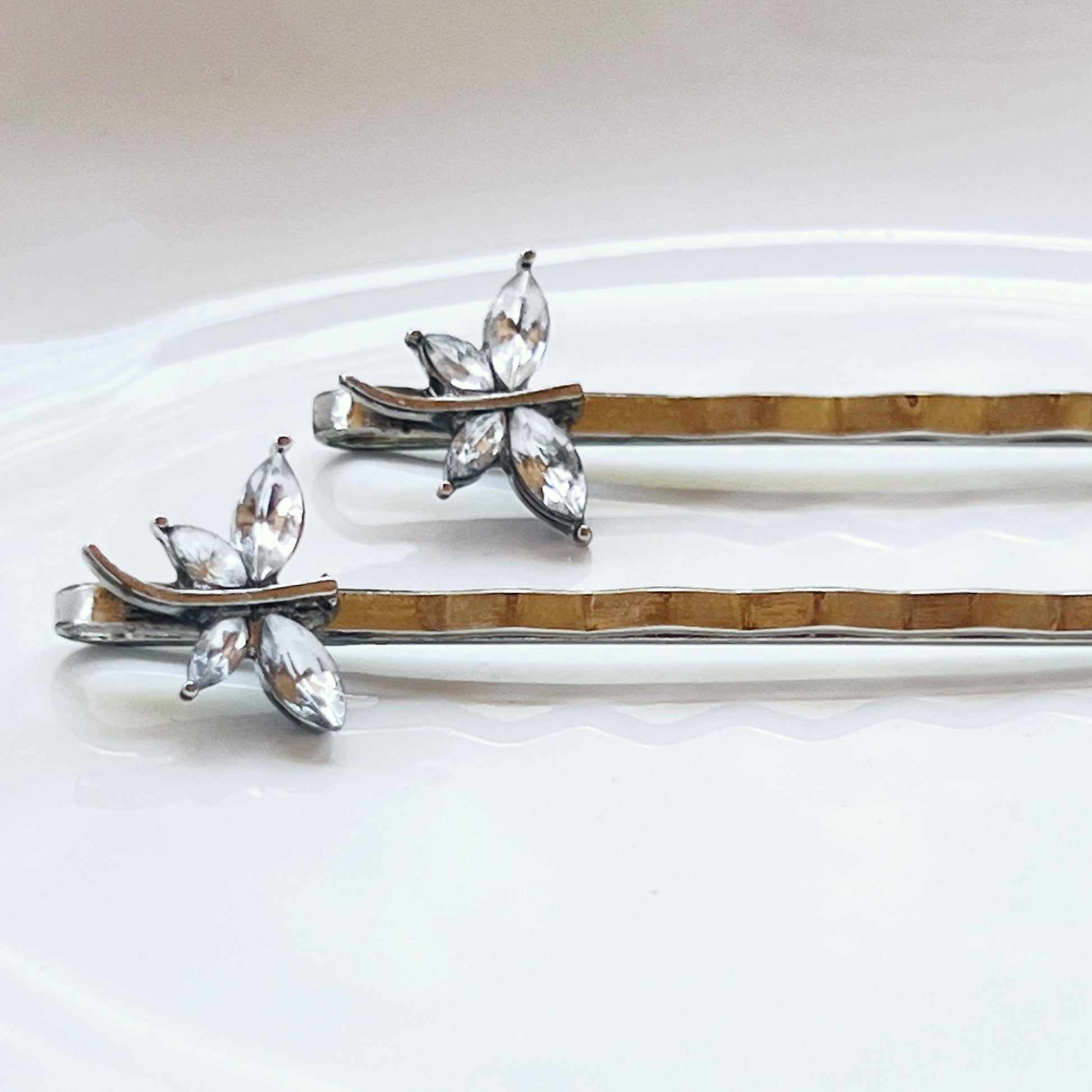 Clear rhinestone dragonfly bobby pins on white surface