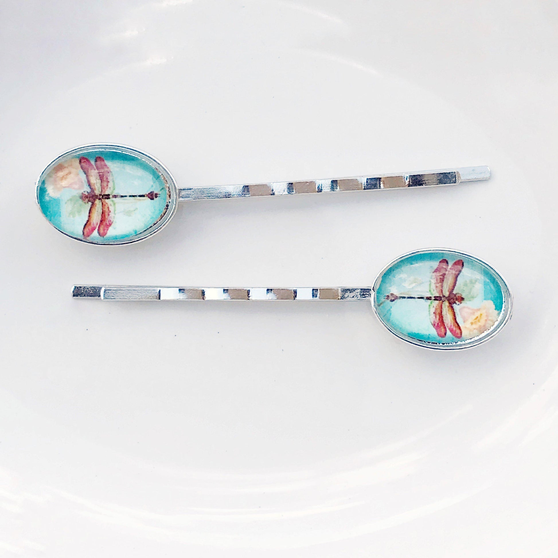 Side view of floral and dragonfly hair pins showing gold tone and detail