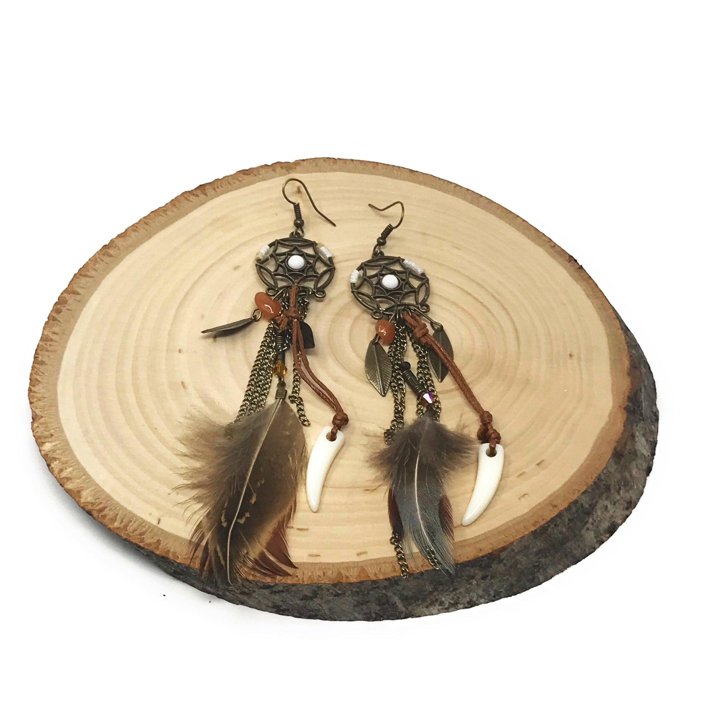 Flat lay of dream catcher feather earrings with faux feathers and metal charm