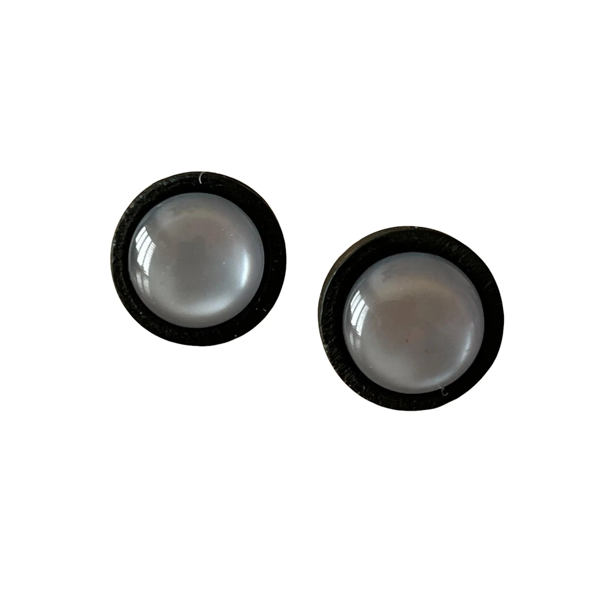 Two round gray earrings with black borders on a white background