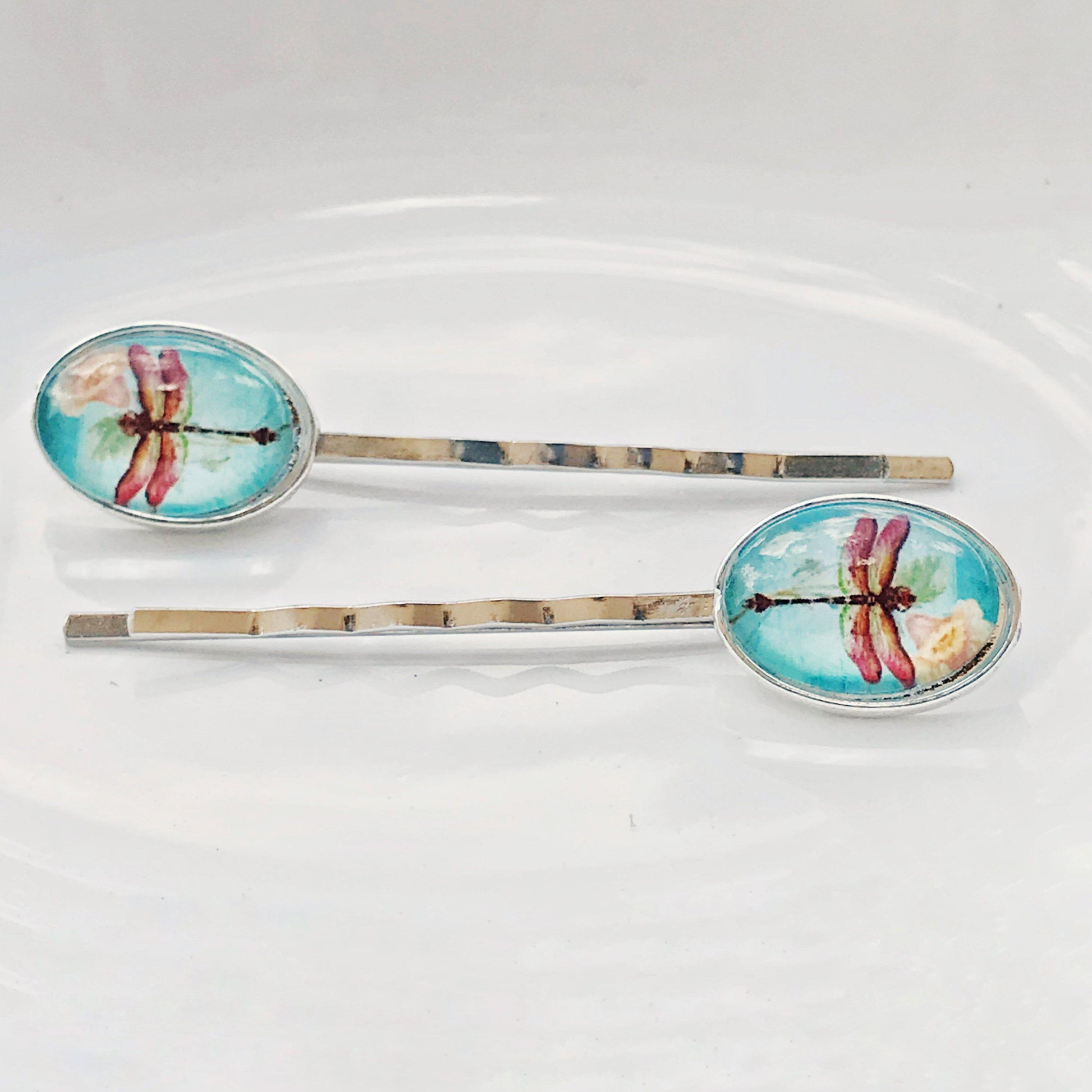 Pair of handmade hair clips with dragonfly and floral designs in gold tone