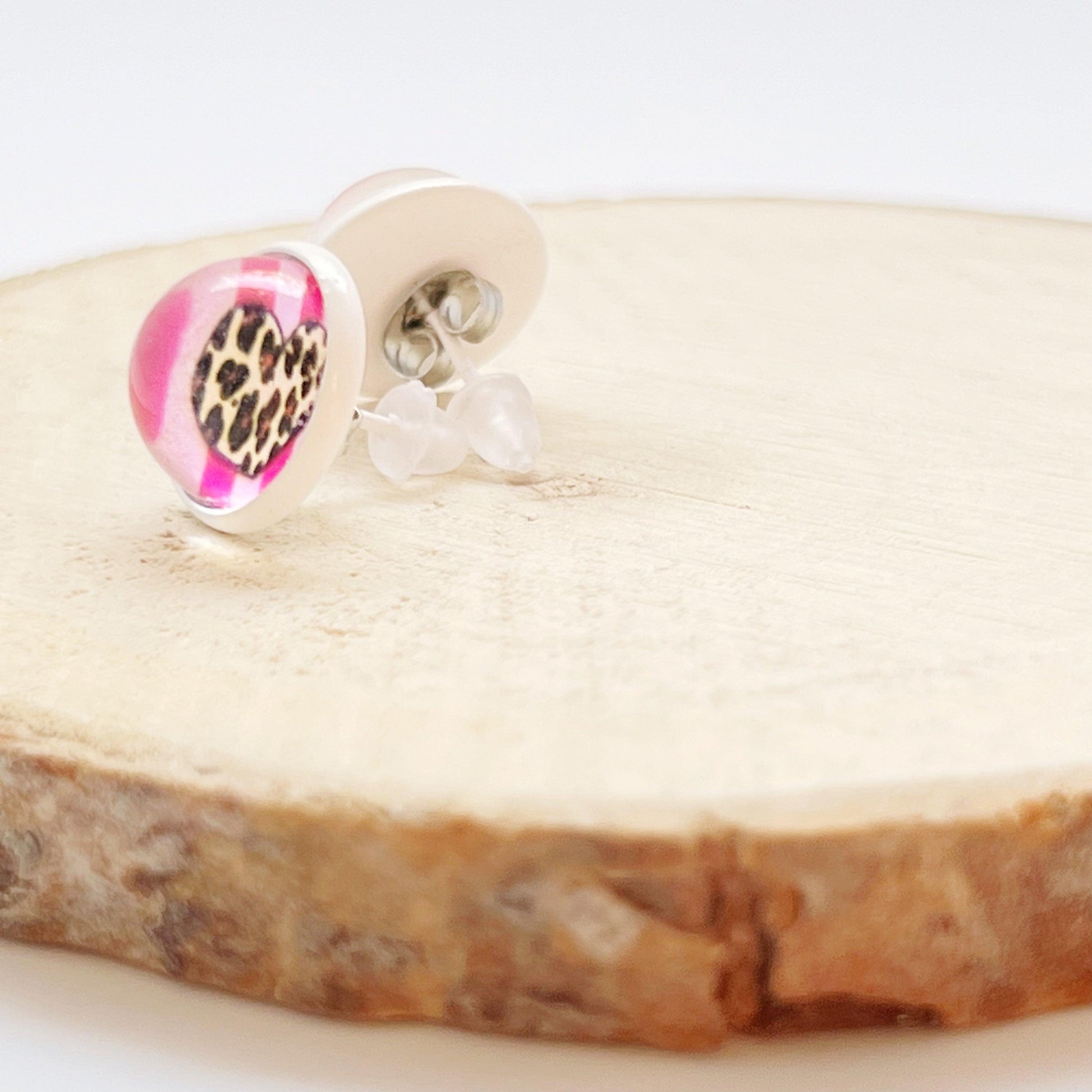 Handmade animal print heart earrings styled with soft lighting and props