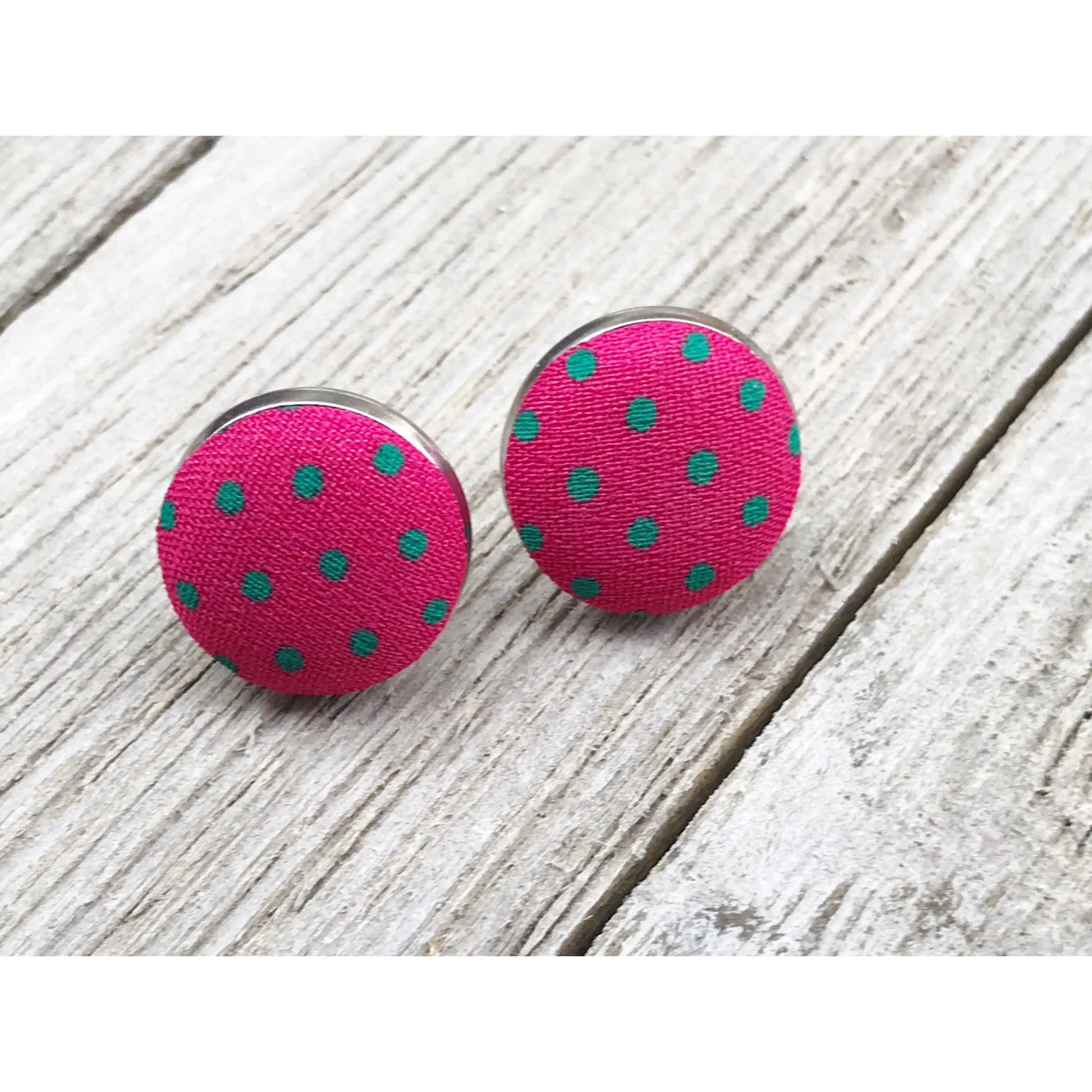 Pink polka dot earrings on a whitewashed wooden surface