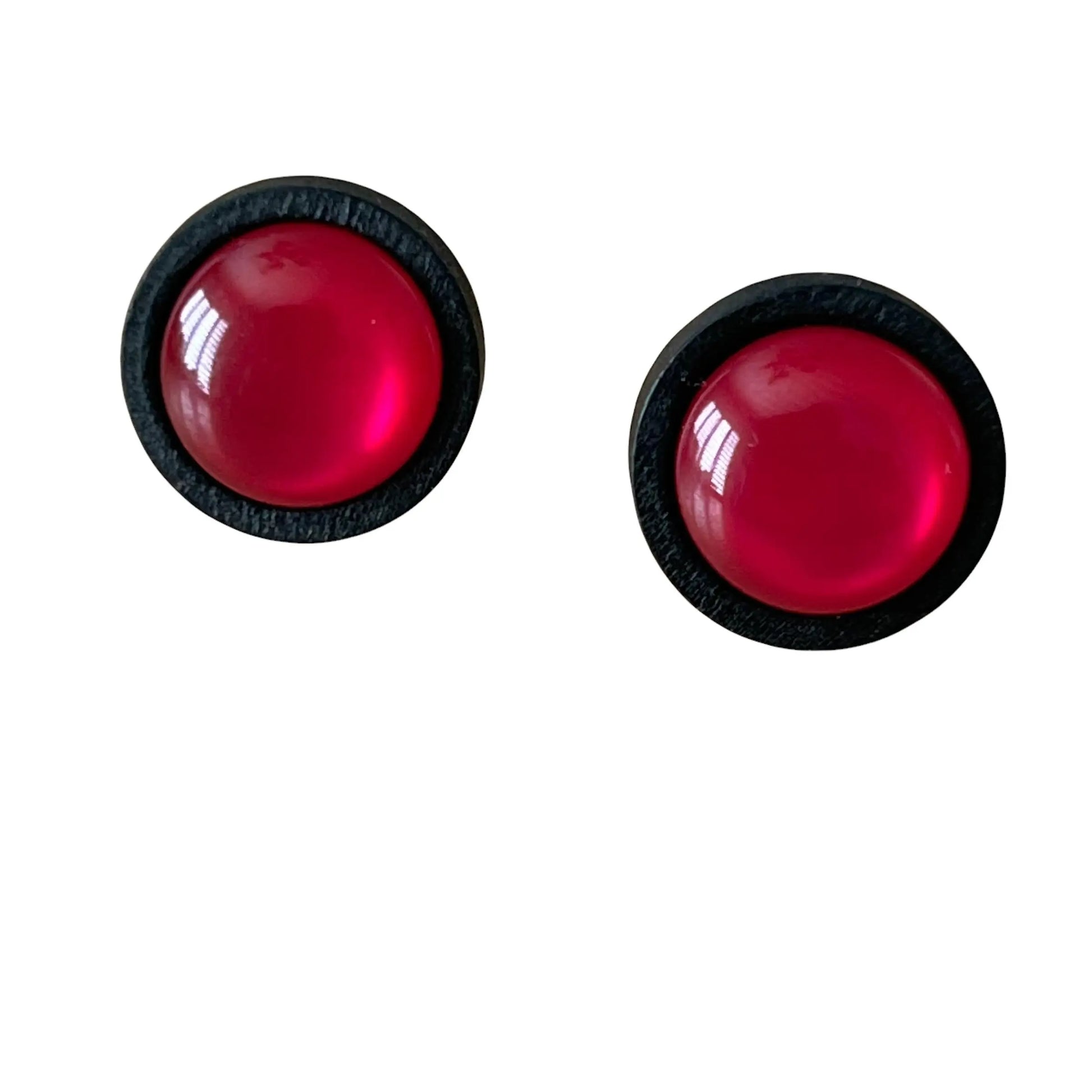 A pair of pink earrings with black borders on a white background