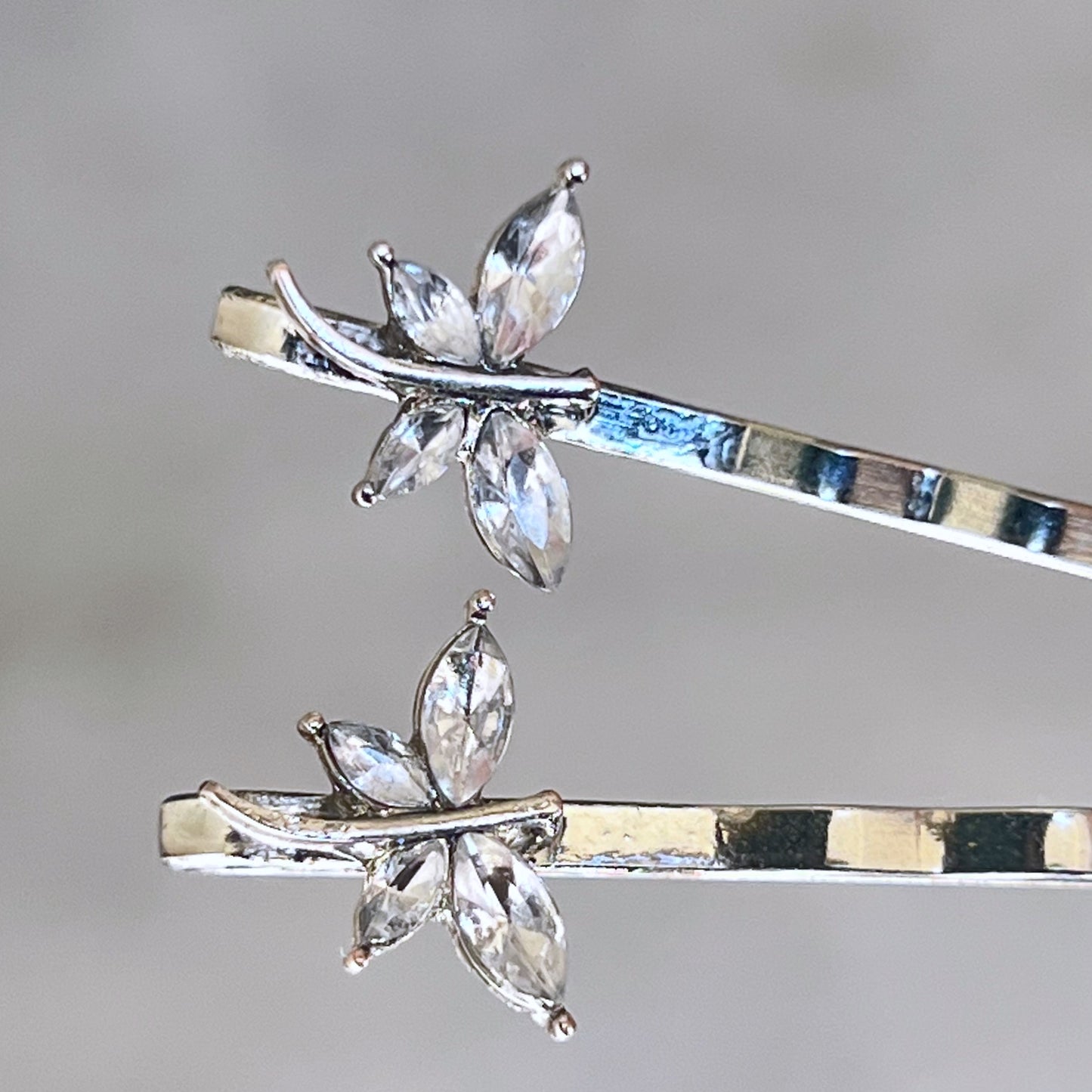 Close-up of silver hair pins with clear rhinestone dragonfly accents