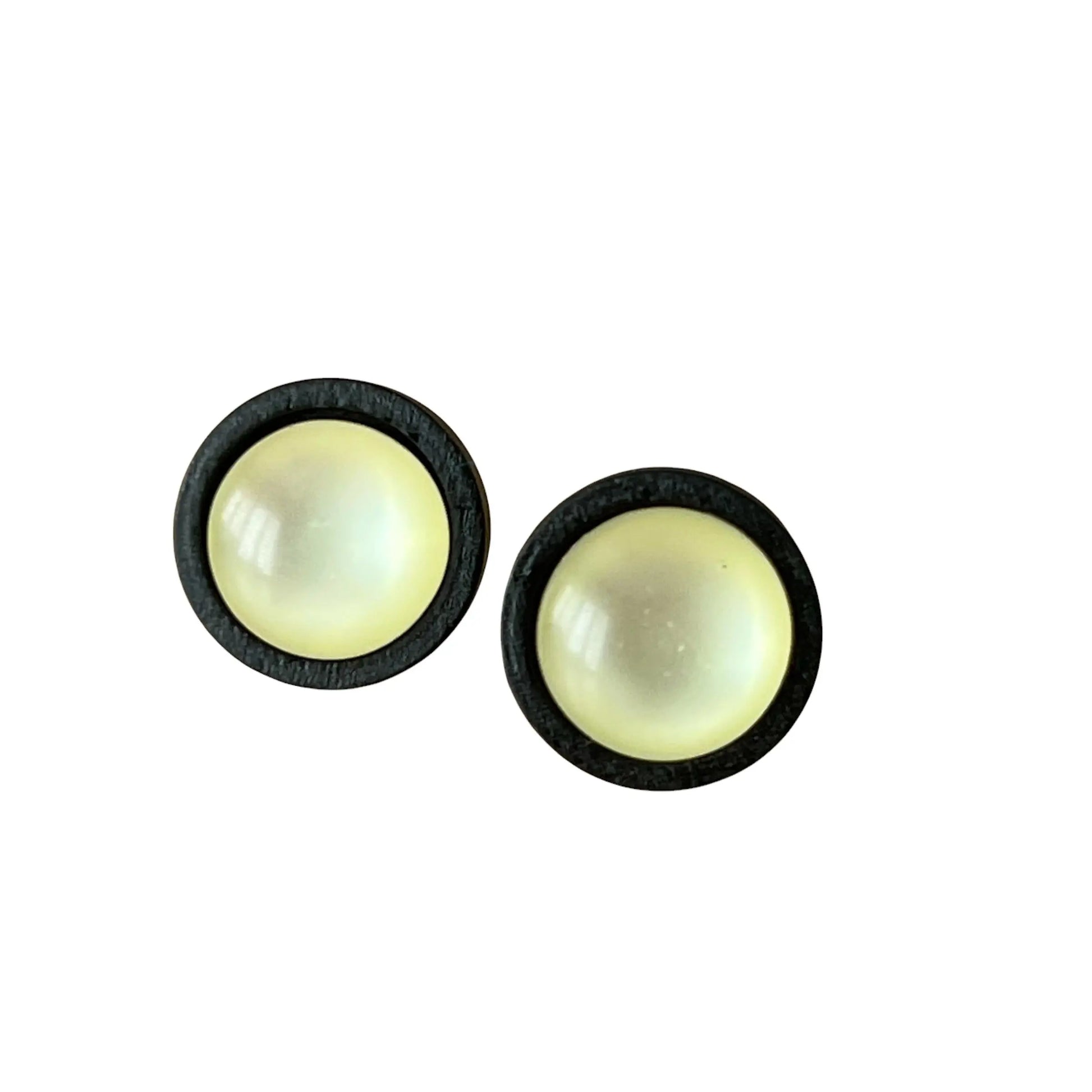 Pair of round earrings with a yellow center and black border on a white background