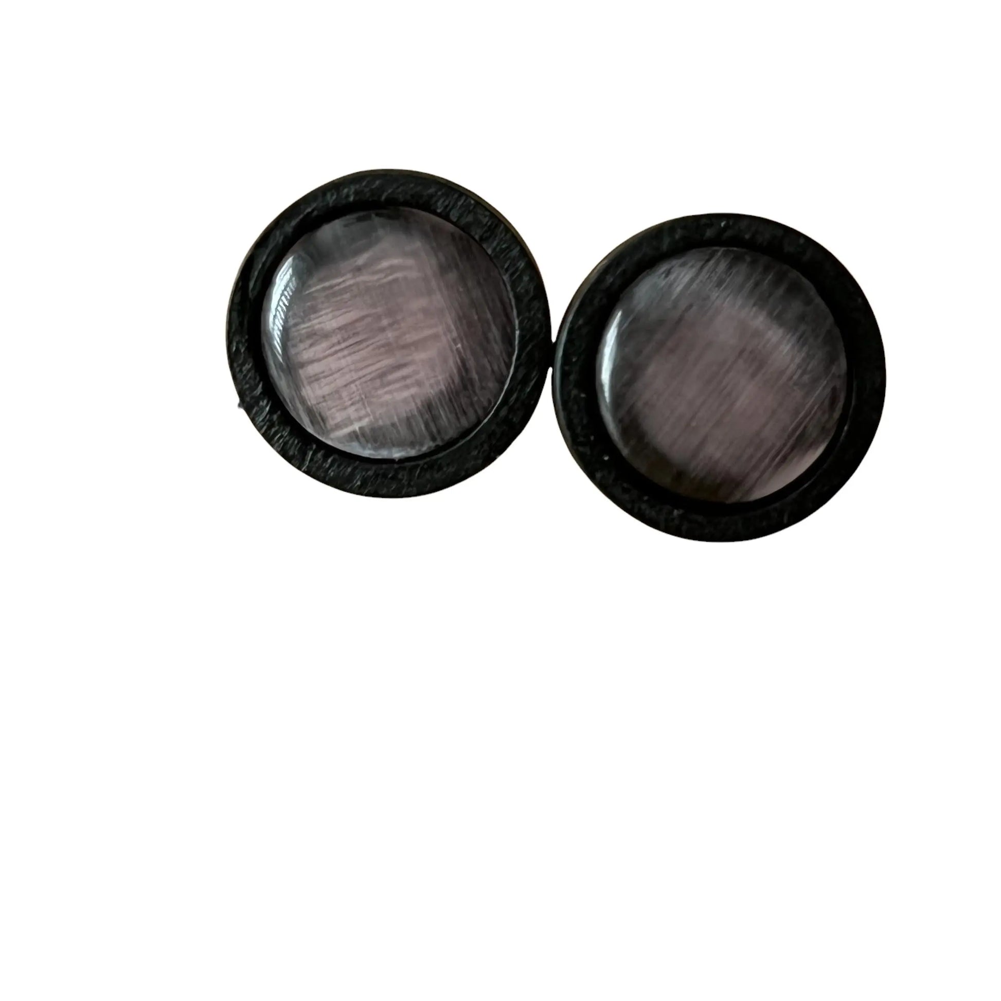 Pair of black circular earrings with glass centers on a white background