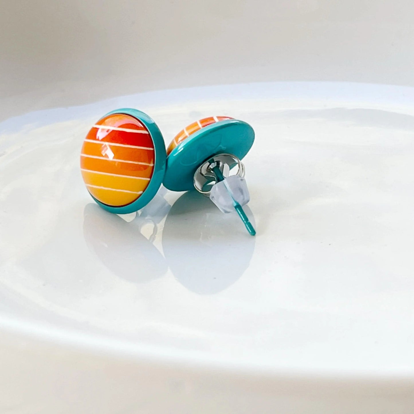 Round orange gradient striped stud earrings with teal borders showing back of earrings 