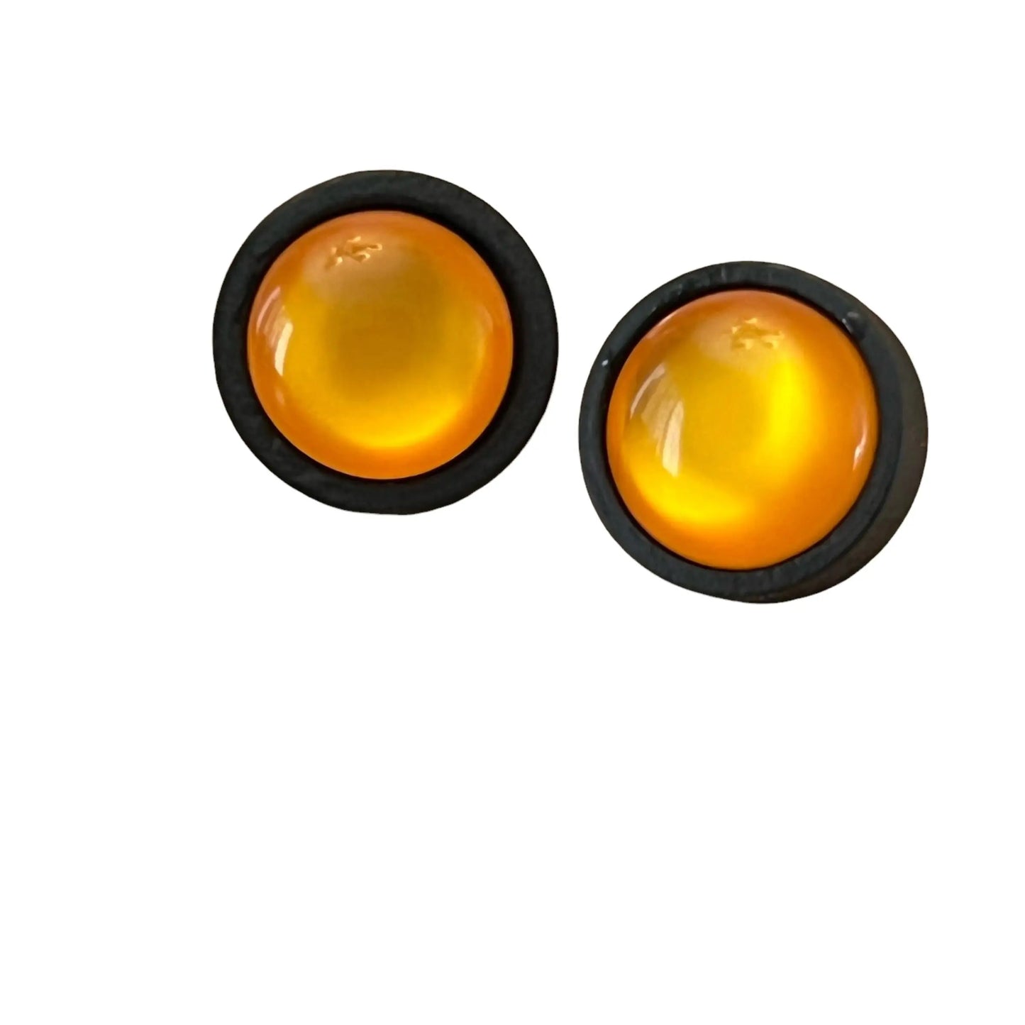 Two round orange earrings with black rims on a white background